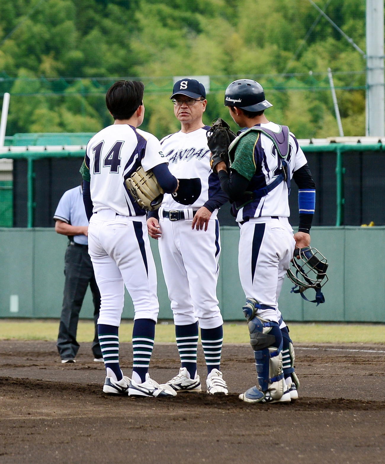 初回のピンチでマウンドで声をかける静岡産大・萩原監督（中央）