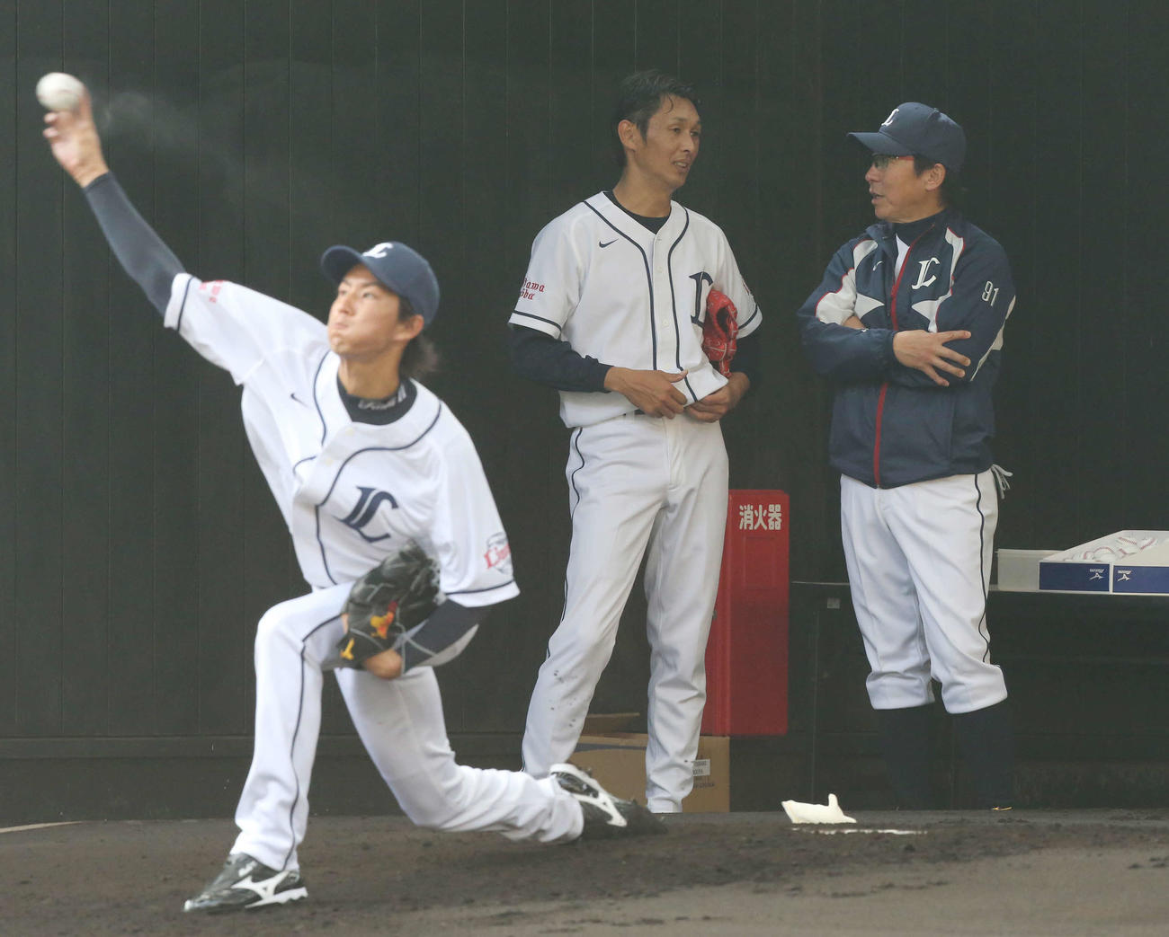 投球練習後、清川コーチ（右）と話す西口。手前は岸（2014年2月1日撮影）