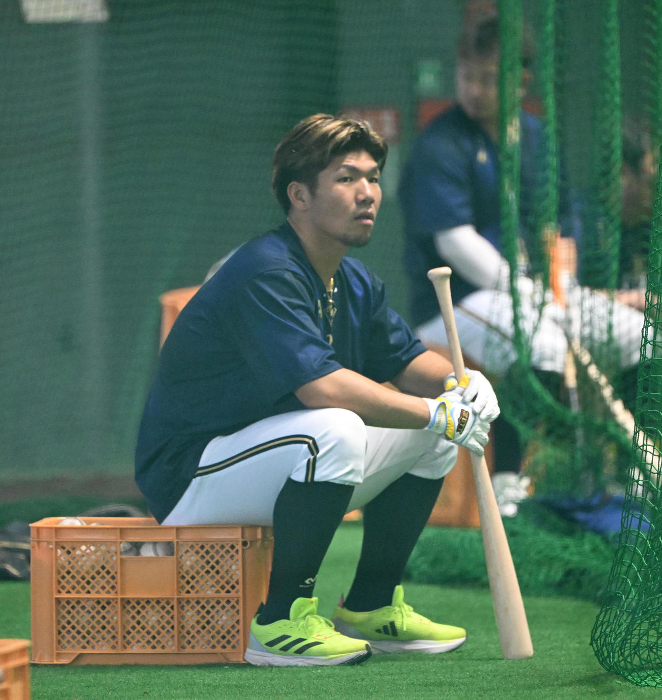 バットを手にケースに座るオリックス頓宮（撮影・和賀正仁）