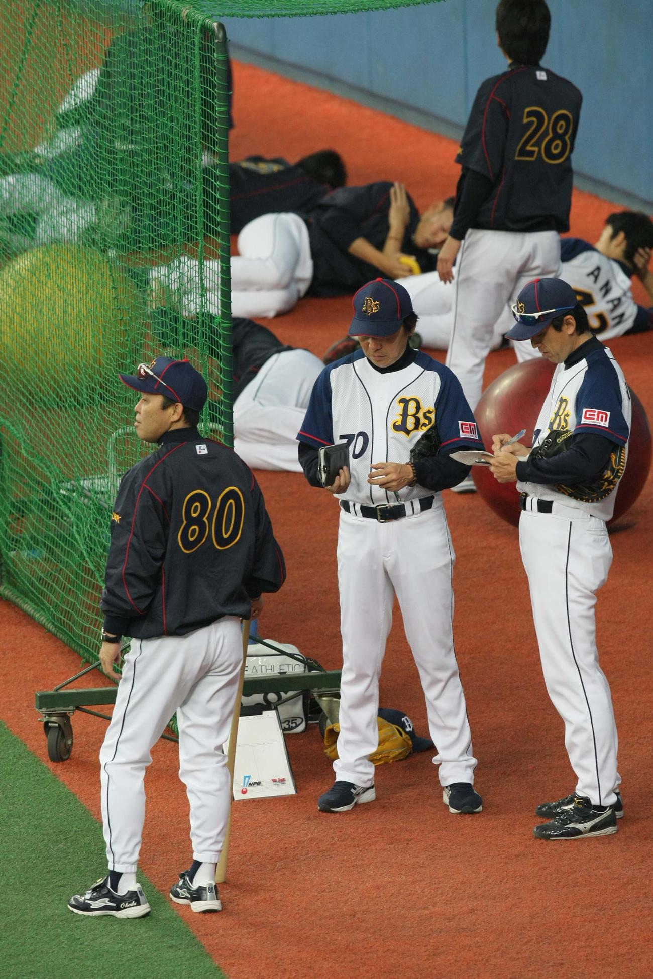 2010年5月5日、オリックス練習　岡田彰布監督（左）と話し合う星野伸之投手コーチ（右）と清川栄治投手コーチ