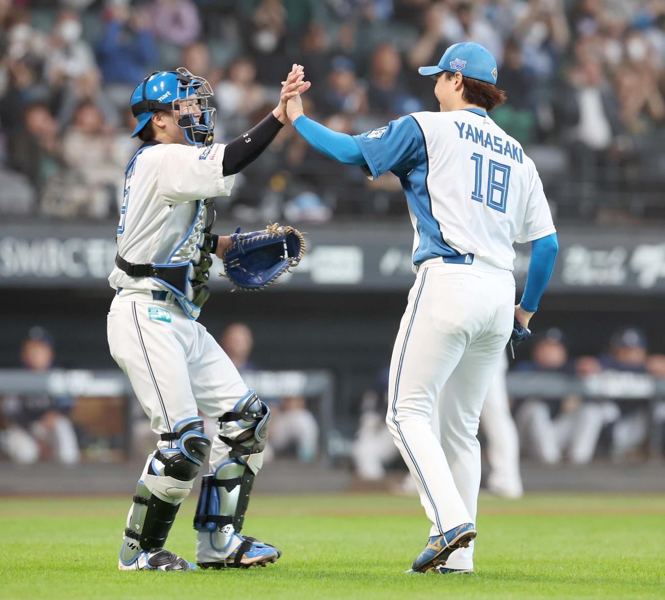 日本ハム対西武　完投勝利を挙げた山崎（右）とハイタッチする伏見（撮影・黒川智章）