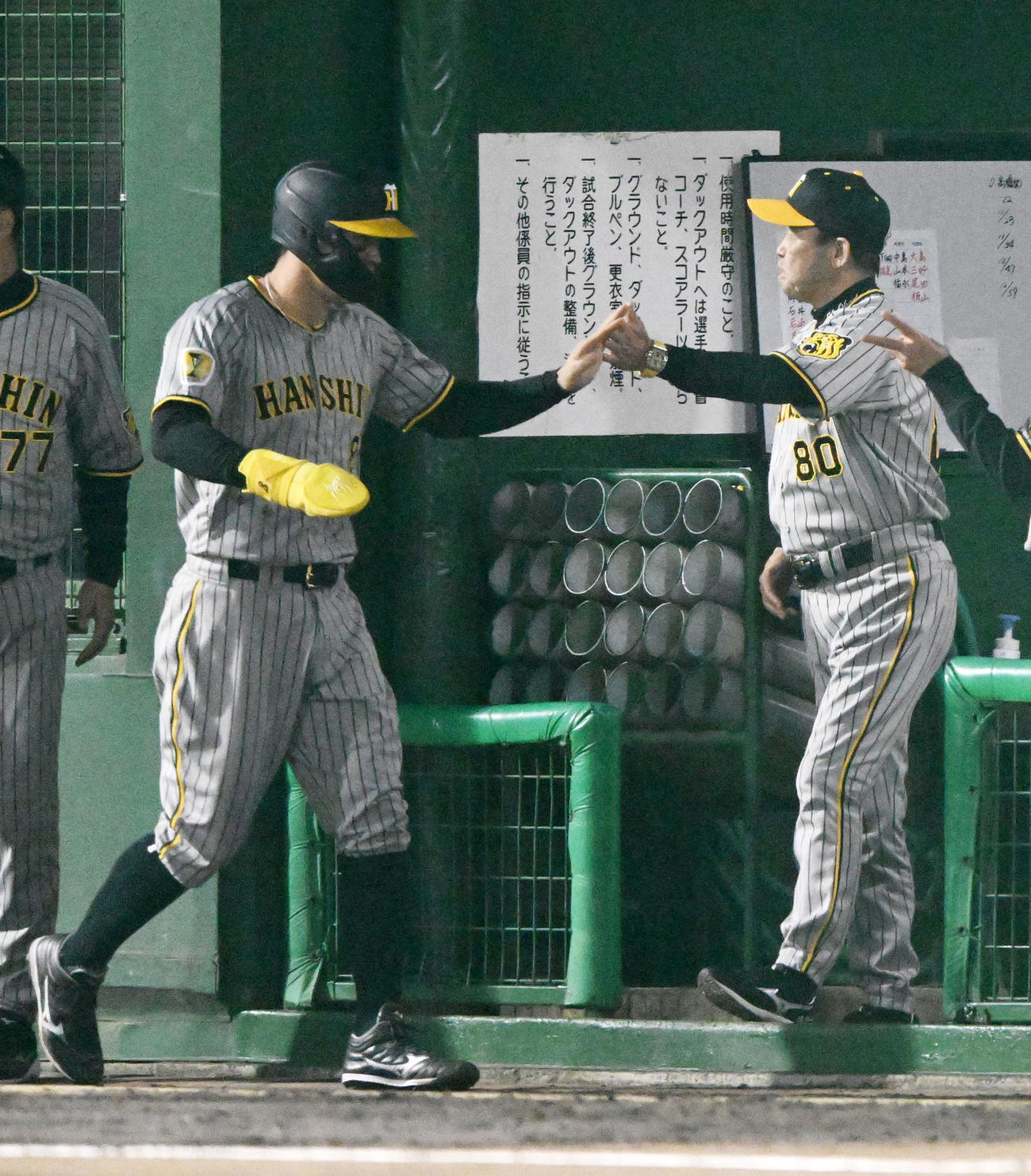 中日対阪神　6回表阪神1死一、三塁、坂本の二ゴロで生還した佐藤輝（左）を迎える岡田監督（撮影・前岡正明）
