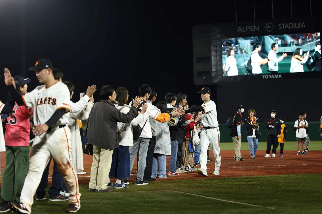 巨人対DeNA DeNAに勝利し、観客とタッチを交わす巨人岸田（手前）と山崎伊（撮影・河田真司）