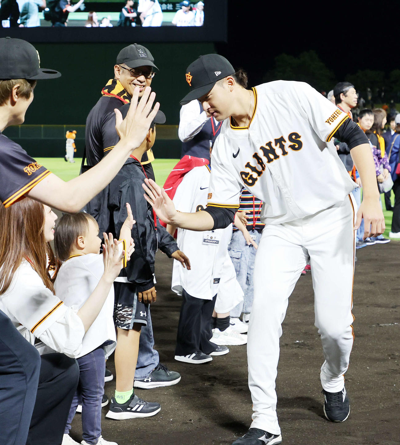 巨人対DeNA　勝利しファンとタッチする巨人堀田（撮影・鈴木正人）