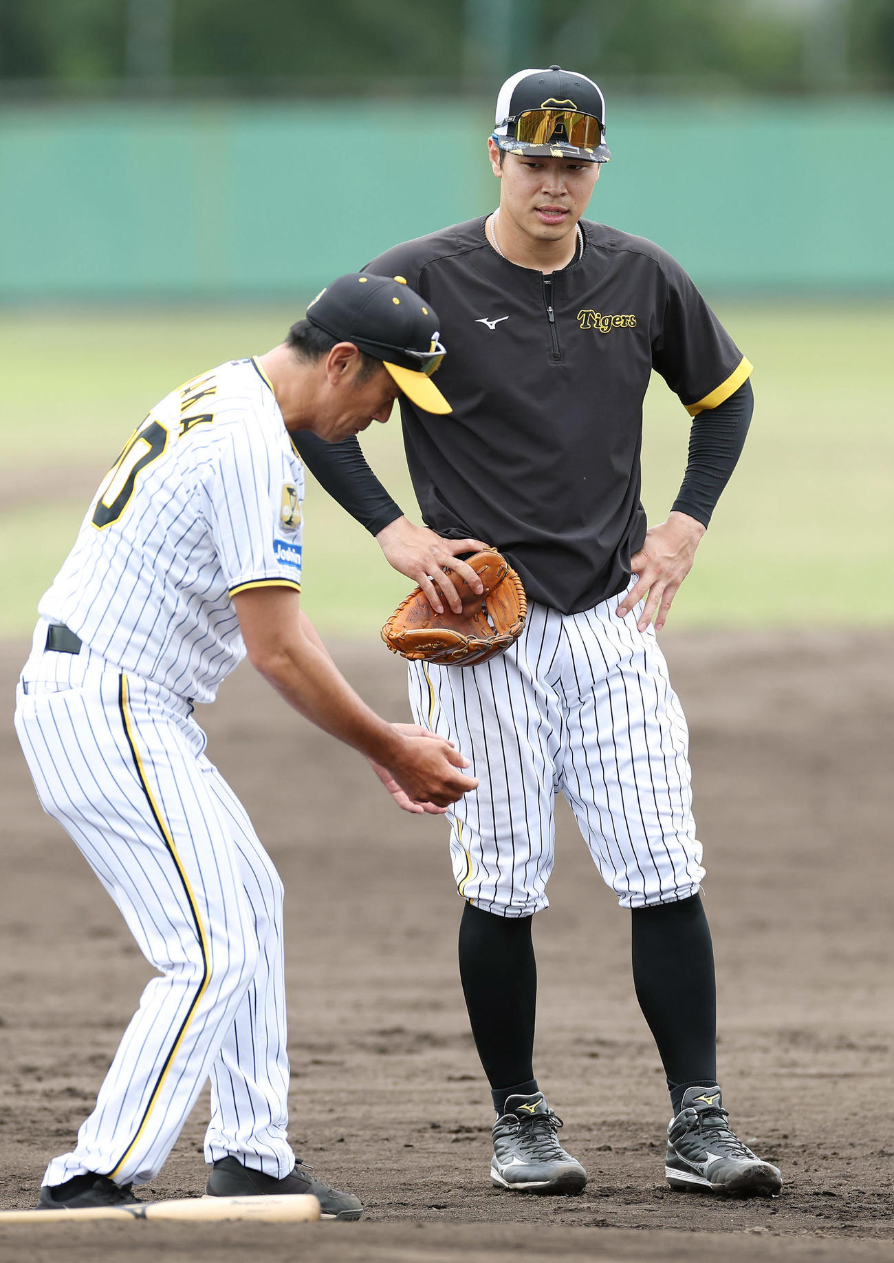 2軍に降格し、阪神田中コーチ（左）から指導を受ける佐藤輝（撮影・前田充）