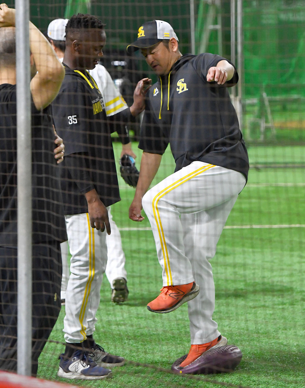 バランスをとる倉野コーチ（右）の肩を押すモイネロ（撮影・岩下翔太）