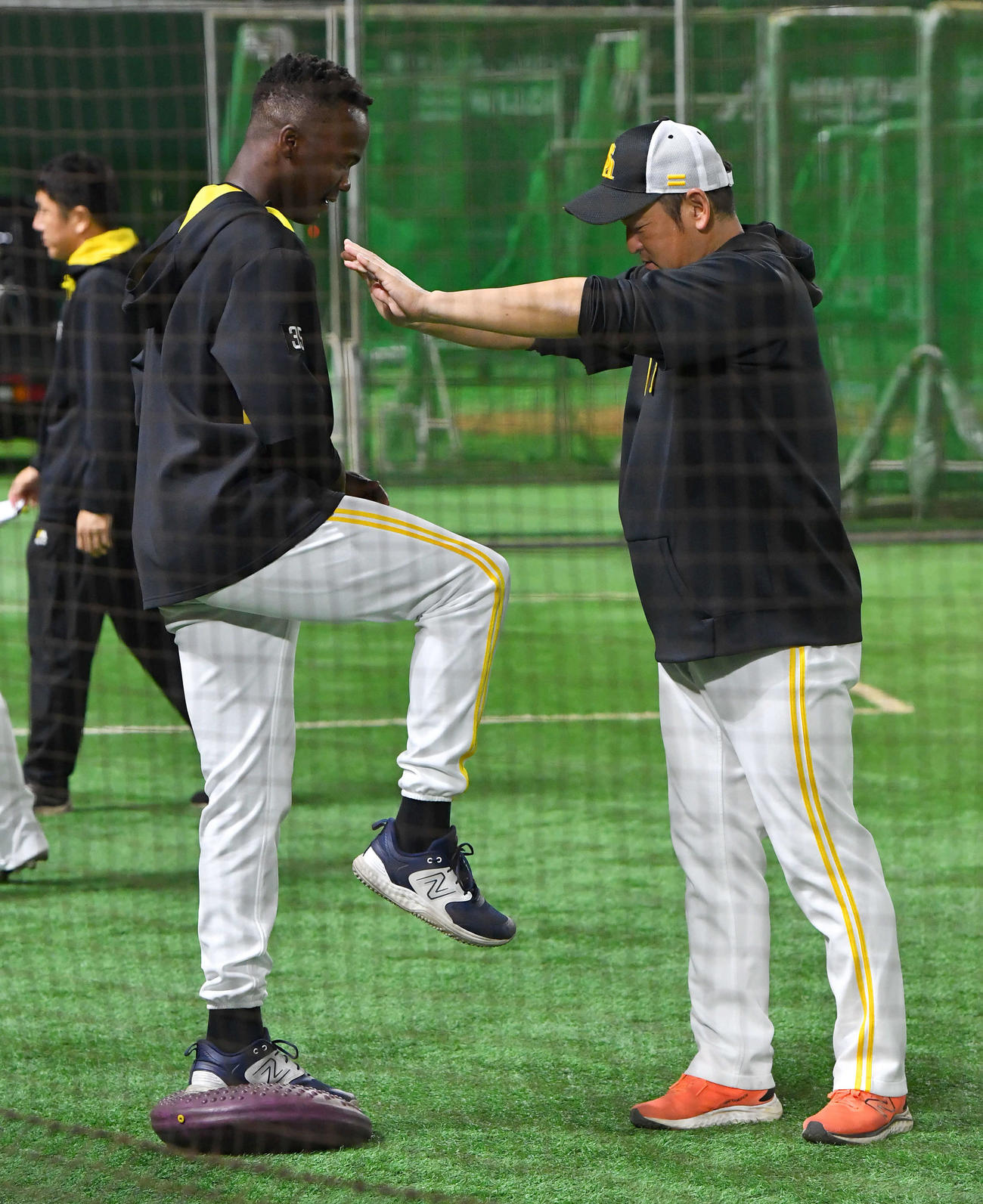 バランスディスクの上で倉野コーチ（右）から押されてもバランスを崩さないモイネロ（撮影・岩下翔太）