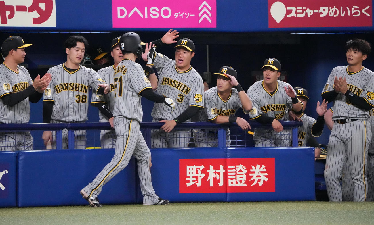 中日対阪神　1回表阪神1死一、三塁、糸原の左前適時打で生還した中野を迎える大山（中央）ら阪神ナイン（撮影・森本幸一）