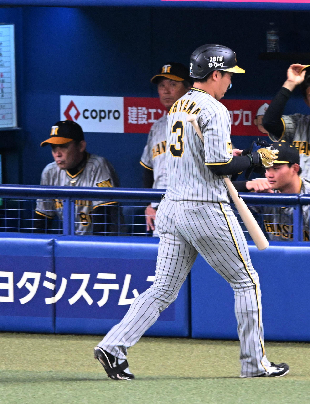 中日対阪神　8回表阪神1死一塁、大山（右）は空振り三振に倒れベンチに戻る。奥は岡田監督（撮影・前岡正明）
