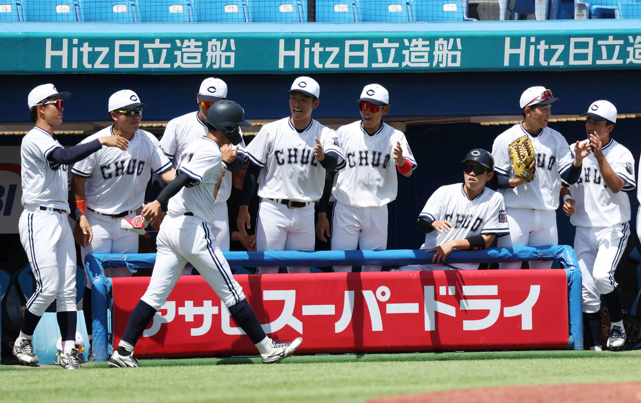 中大対亜大　1回表中大1死満塁、皆川の遊ゴロの間に生還し、チームメートとタッチする佐藤壱（手前）（撮影・宮地輝）