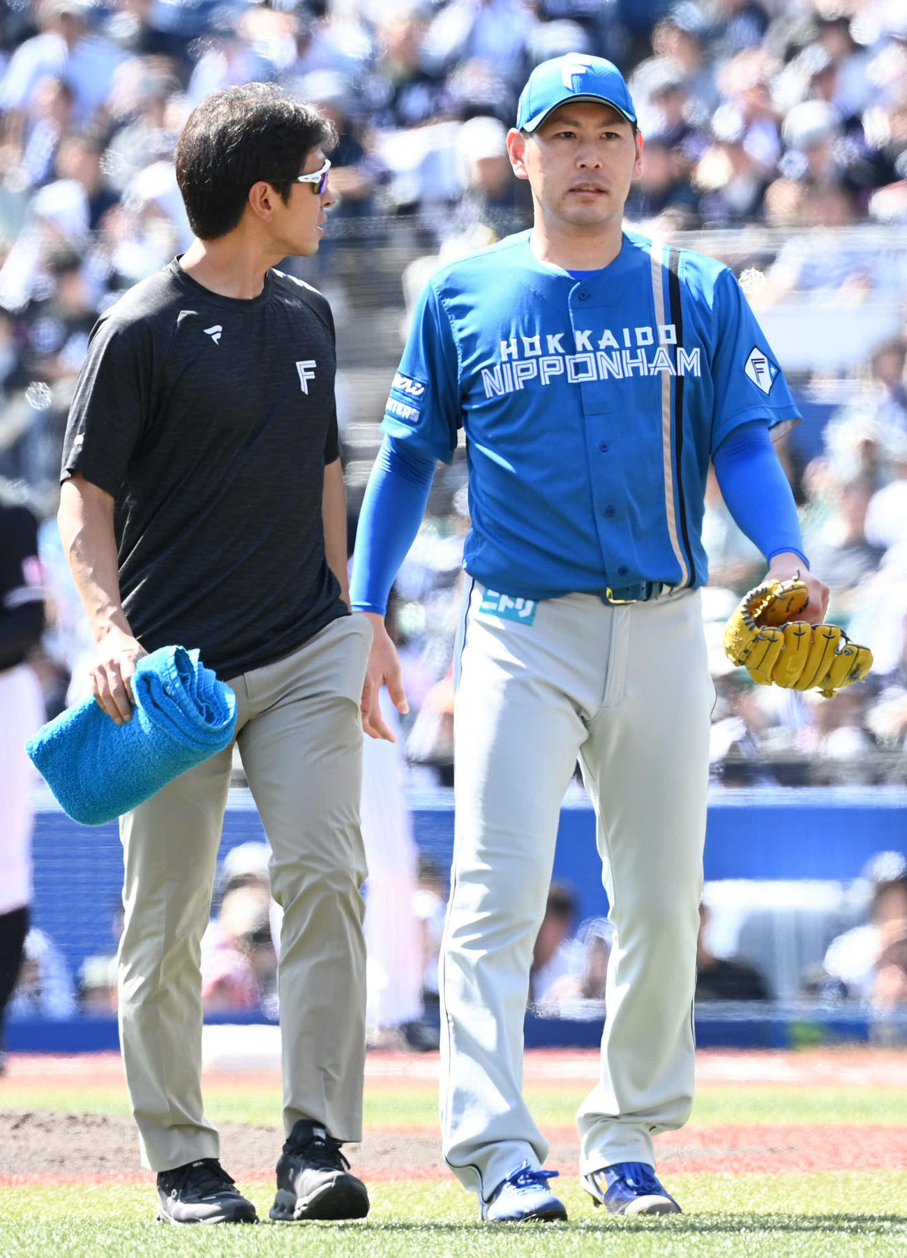 ロッテ対日本ハム　1回裏ロッテ無死一塁、岡の投手強襲内野安打を右足に受けた加藤貴（右）はトレーナーと一緒に治療へ向かう（撮影・山崎安昭）