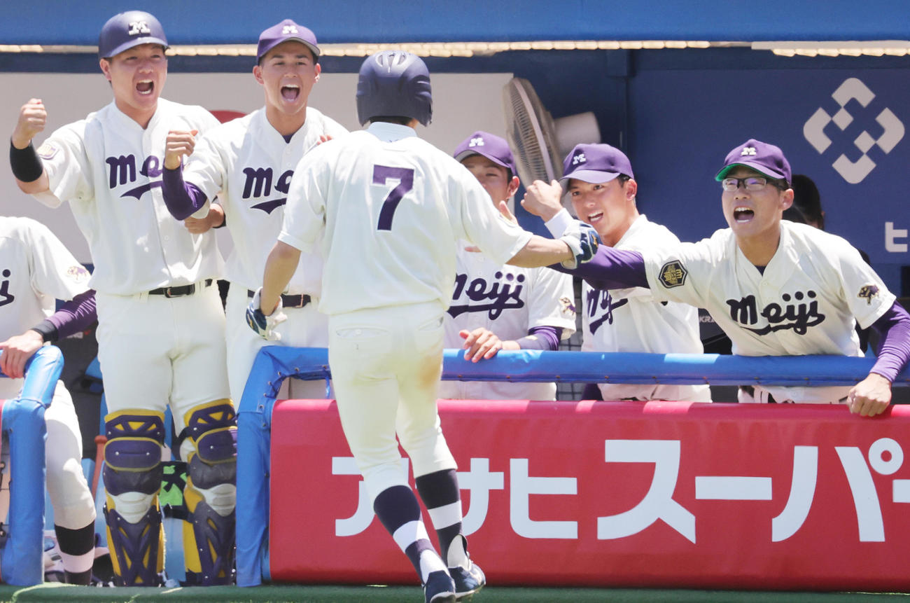 慶大対明大　1回裏明大1死三塁、小島河のニゴロで先制の生還を果たした飯森（手前）を迎える宗山主将（右から2人目）ら（撮影・野上伸悟）