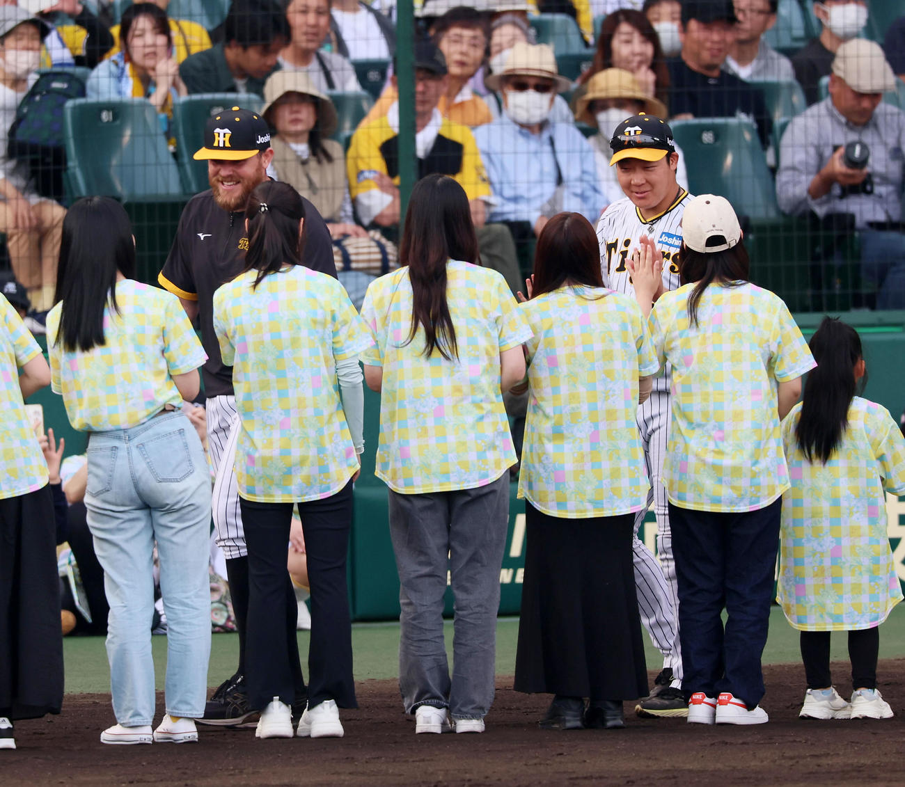 阪神対ヤクルト　TORACOデーで選ばれたファンとタッチするビーズリー（左）と大山（撮影・加藤哉）