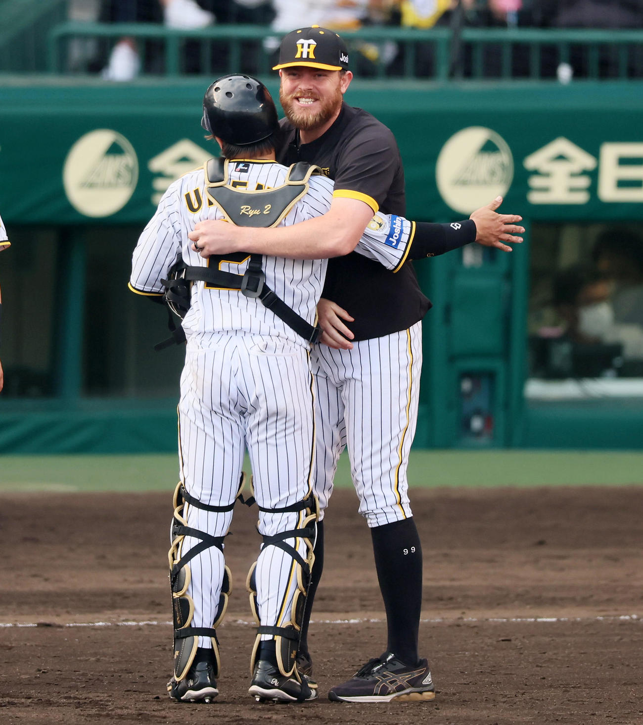 阪神対ヤクルト　今季初勝利を挙げたビーズリー（右）は梅野を笑顔で抱きしめる（撮影・加藤哉）