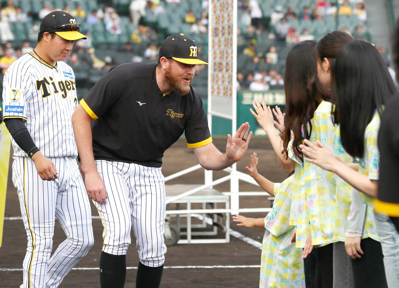阪神対ヤクルト　今季初勝利を挙げたビーズリー（左から2人目）はTORACOデーのファンとタッチする。左は大山（撮影・上山淳一）