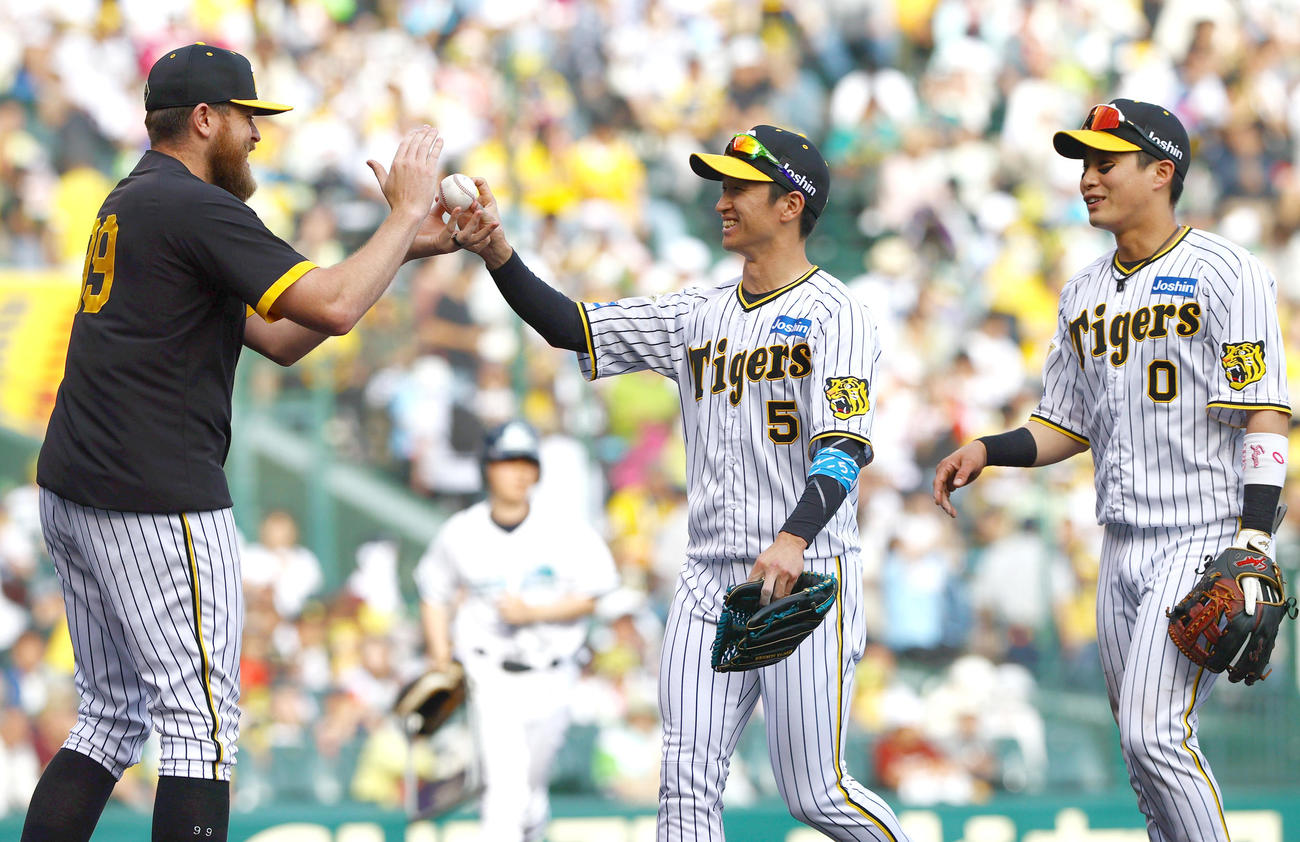 阪神対ヤクルト　ヤクルトに勝利し阪神近本（中央）からウイニングボールを手渡されるビーズリー。右は木浪（撮影・上山淳一）