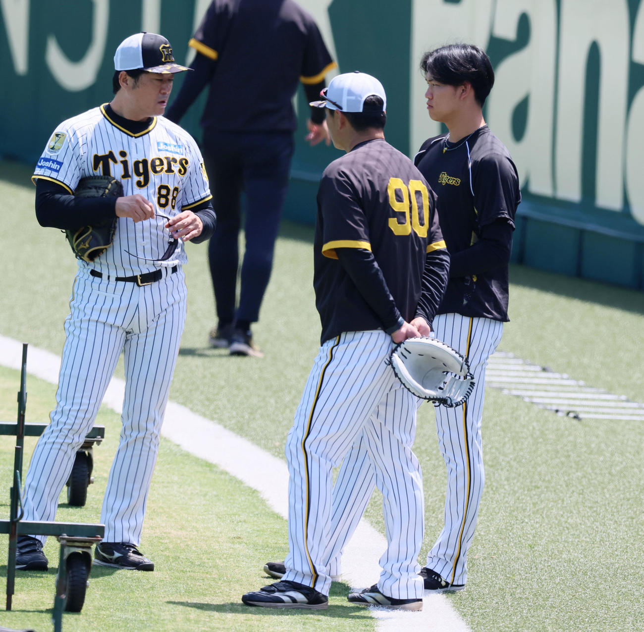 阪神対ヤクルト　練習時、安藤コーチ8日）と話し込む及川。中央は久保田コーチ（撮影・加藤哉）