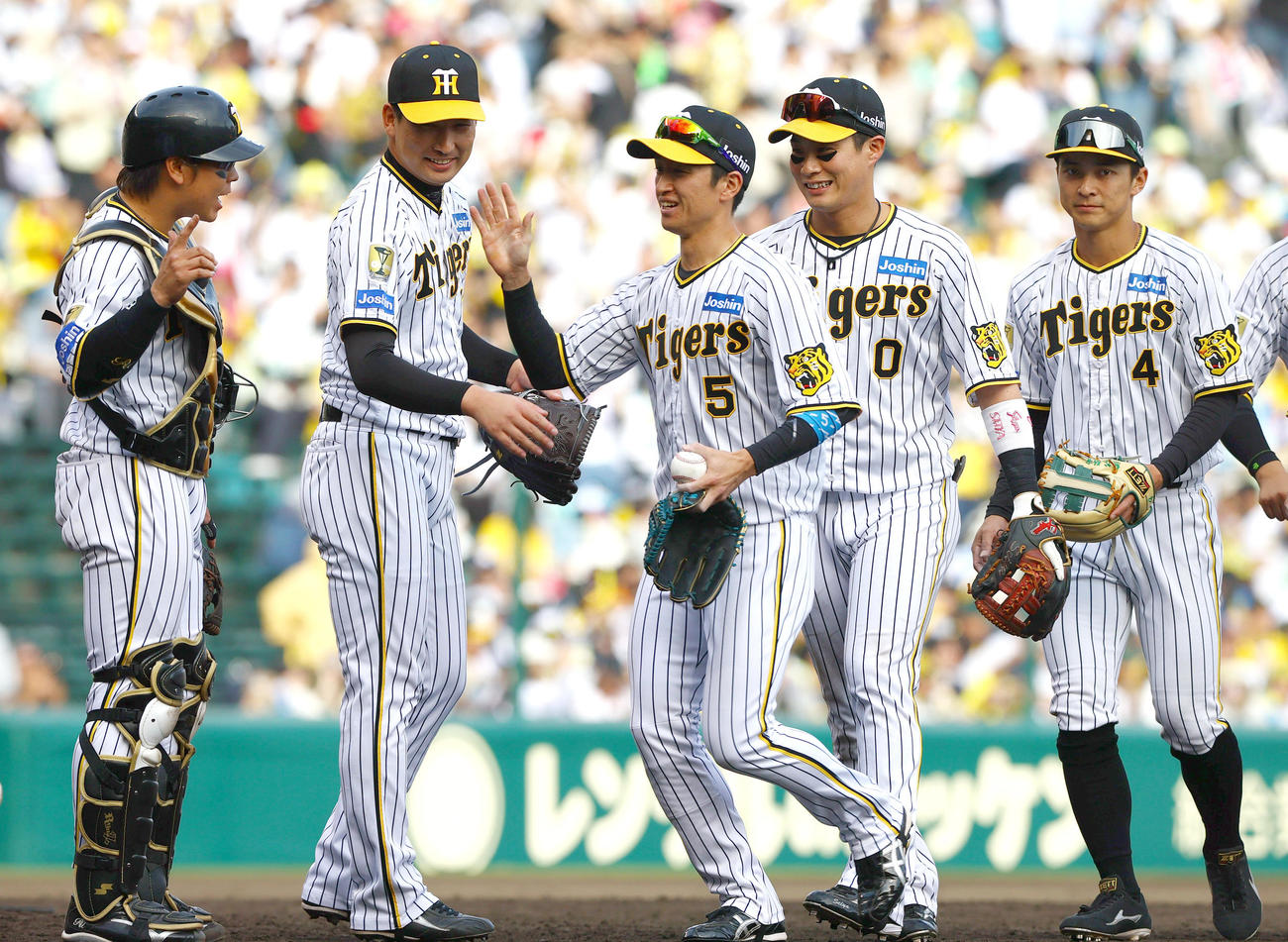 阪神対ヤクルト　試合を締めた阪神岩崎（左から2人目）はナインとタッチをかわす（撮影・上山淳一）