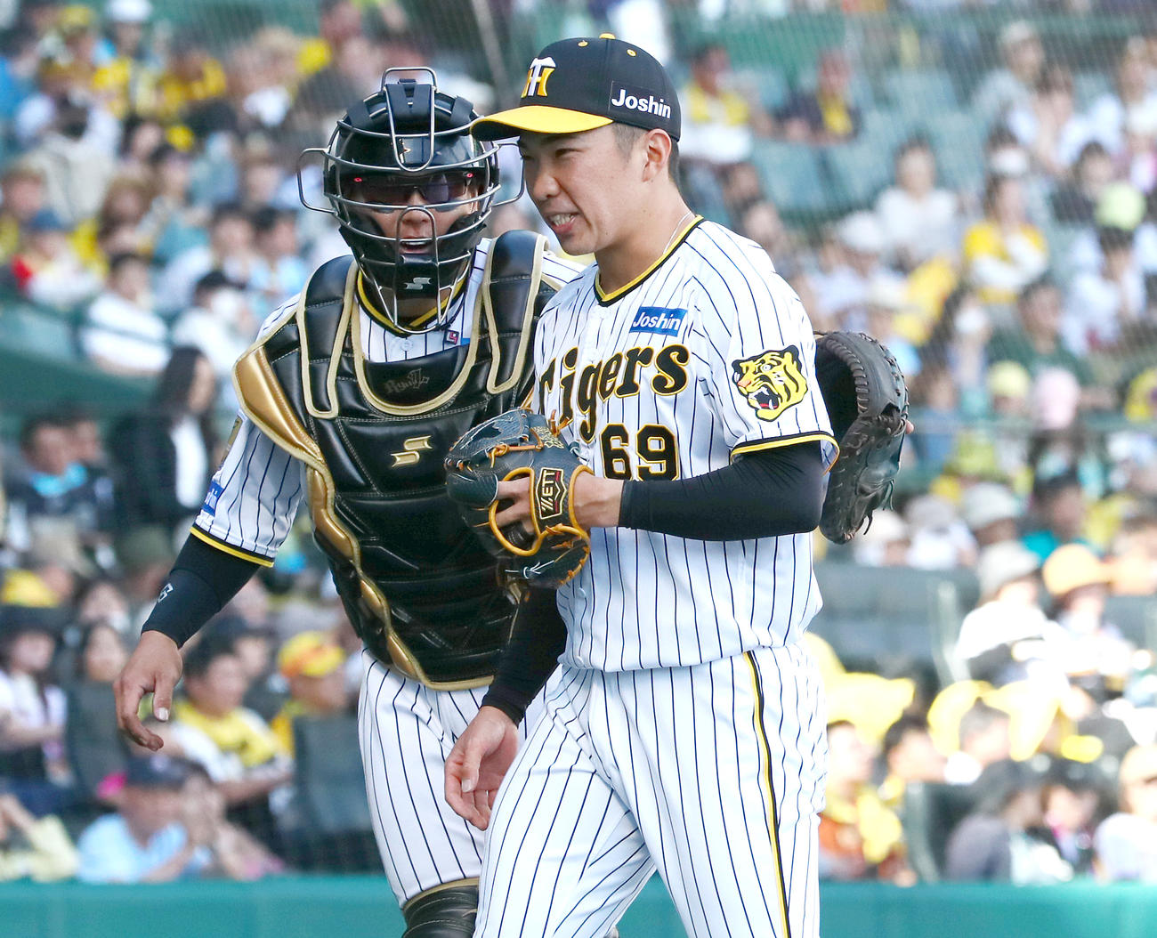 阪神対ヤクルト　7回表に登板の阪神石井（右）は3人で終え梅野から祝福され笑顔を見せる（撮影・上山淳一）