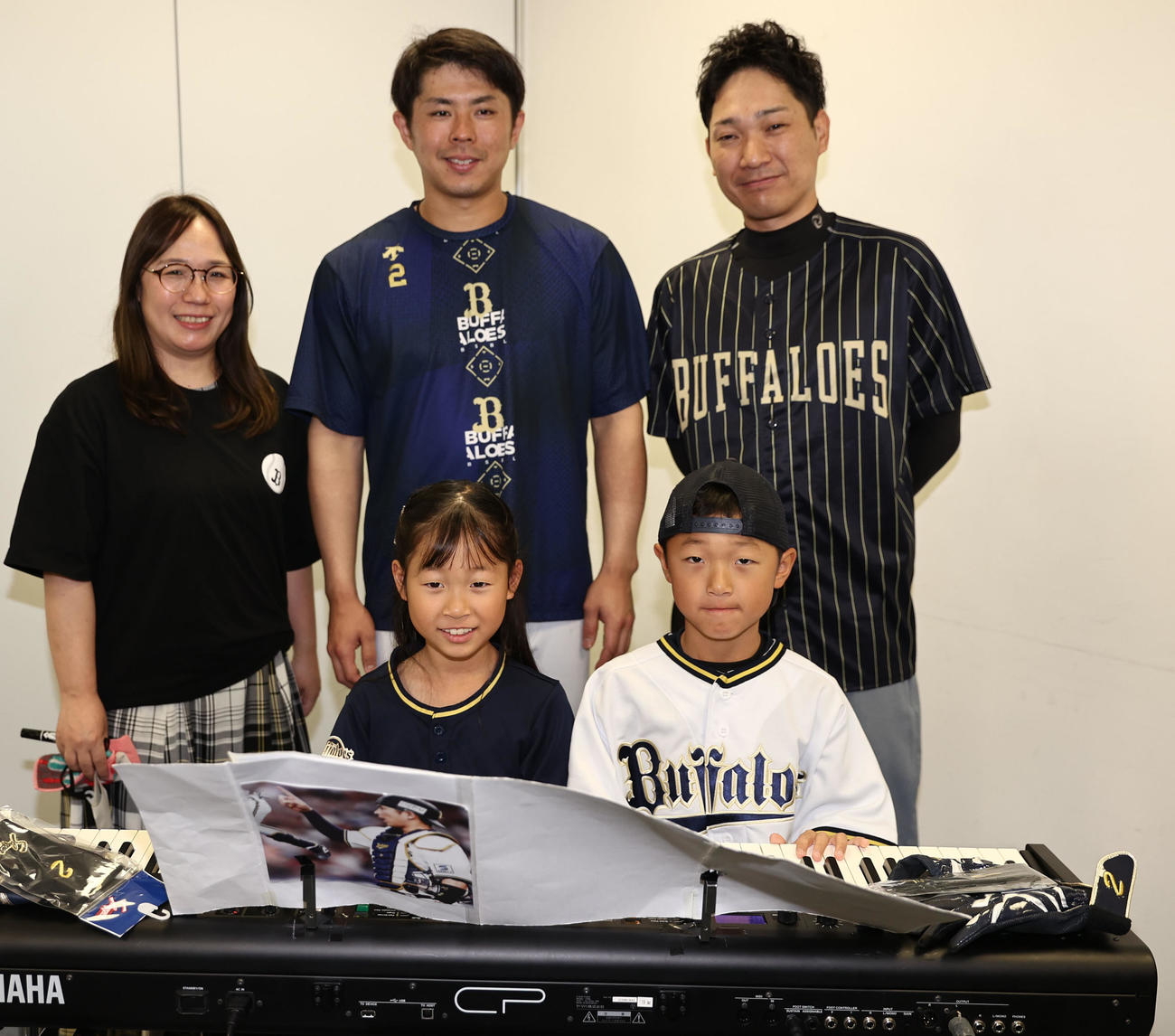 オリックスの「オリ夢企画！あなたの夢を叶えます」で。若月健矢の前で「パラダイス銀河」を連弾した（右から）原田瑛旬さん、夏瑛乃さんのきょうだいは父・竜二さん、母・悦子さんと記念写真に納まる（撮影・西尾就之）