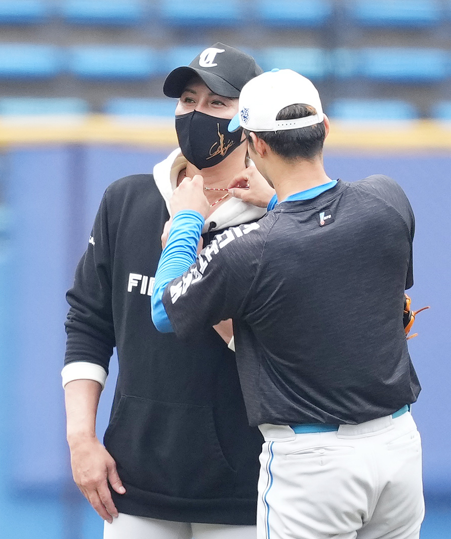 ロッテ対日本ハム　試合前、新庄監督（左）のつけていたネックレスを外す日本ハム石井（撮影・菅敏）