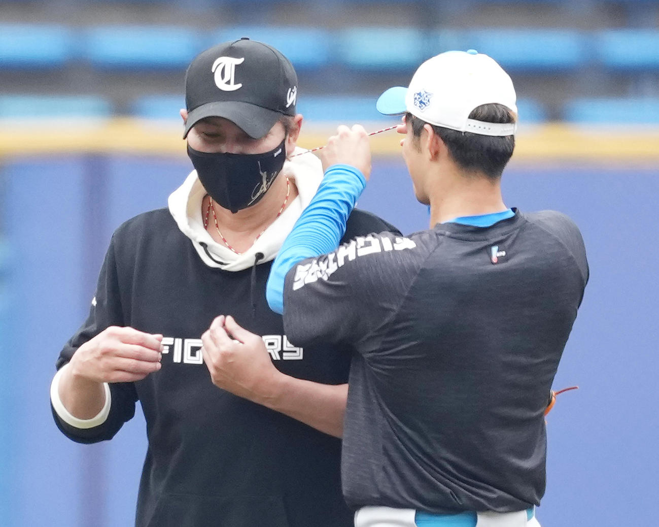ロッテ対日本ハム　試合前、新庄監督（左）のつけていたネックレスを外す日本ハム石井（撮影・菅敏）