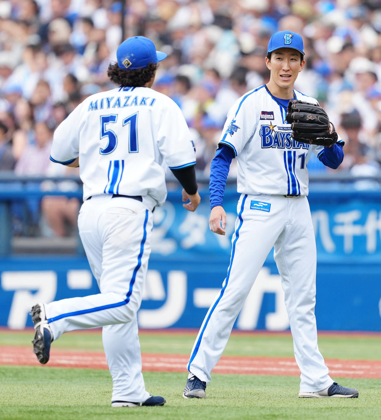 DeNA対中日　5回表終了後、DeNA三塁手宮崎（左）とタッチを交わす先発の大貫（撮影・江口和貴）