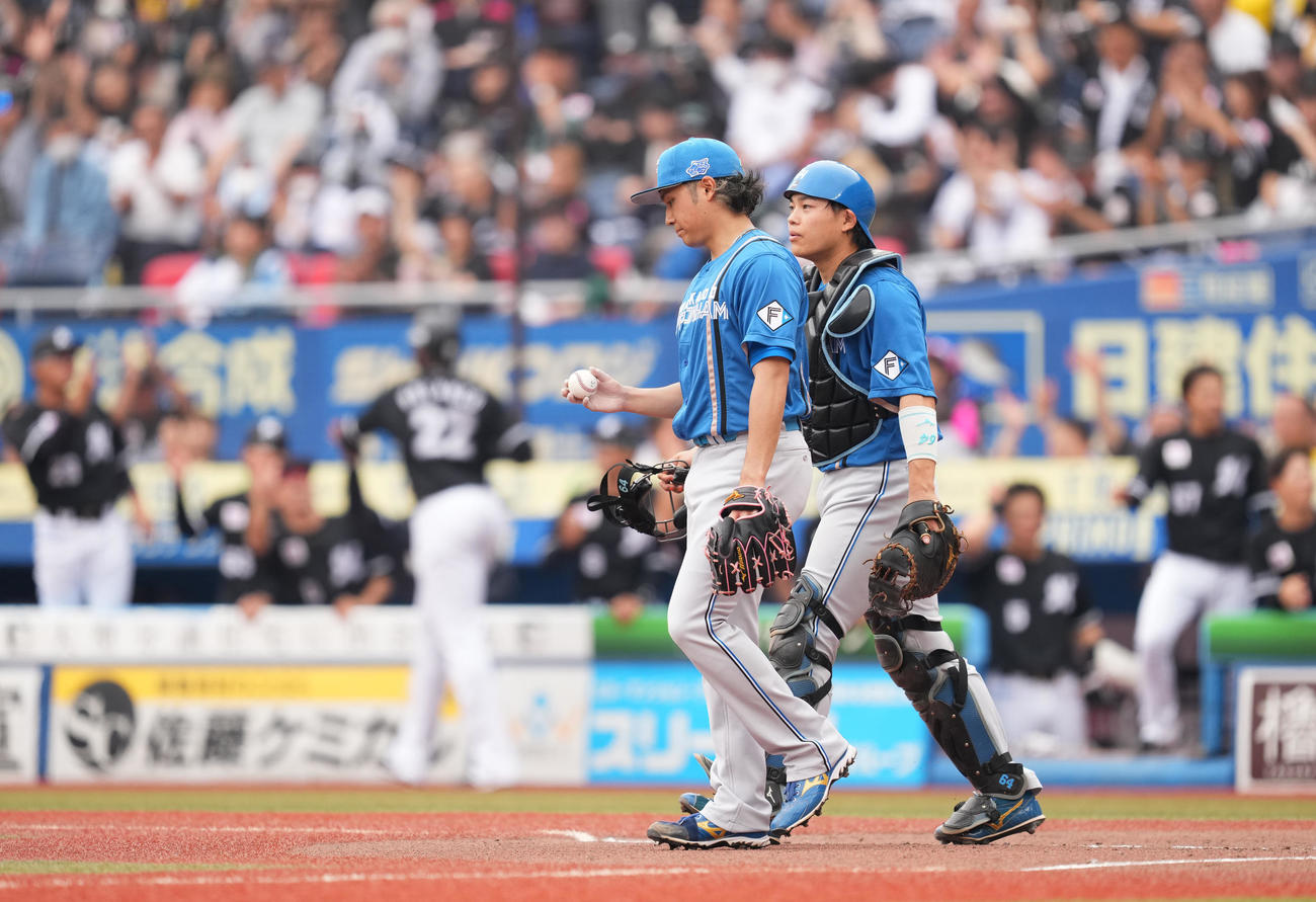 ロッテ対日本ハム　1回裏ロッテ1死二、ソト（後方）に先制の2点適時打を打たれ、肩を落とす伊藤。右は捕手田宮（撮影・菅敏）
