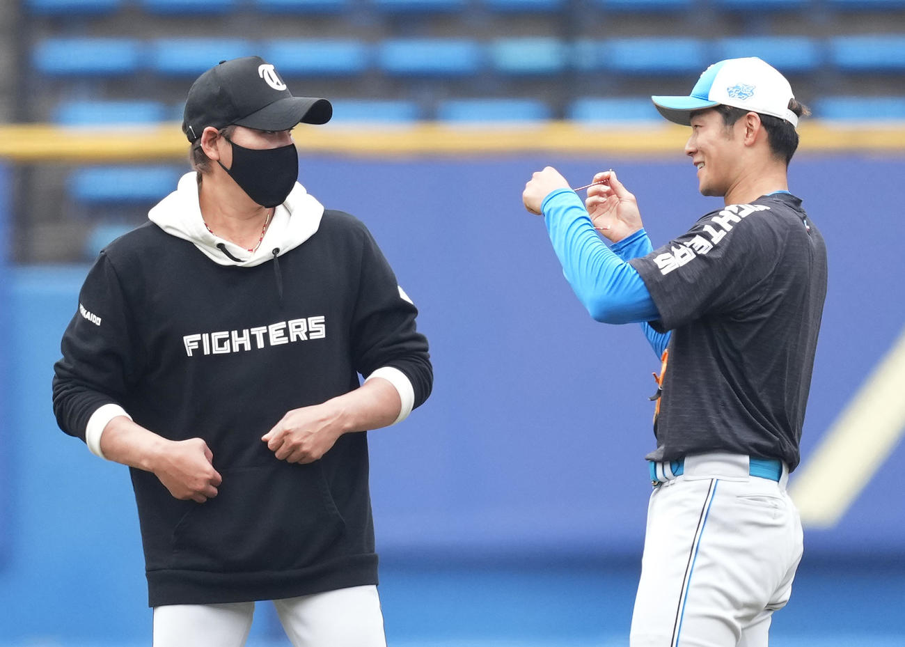 ロッテ対日本ハム　試合前、石井（右）につけていたネックレスをプレゼントする日本ハム新庄監督（撮影・菅敏）