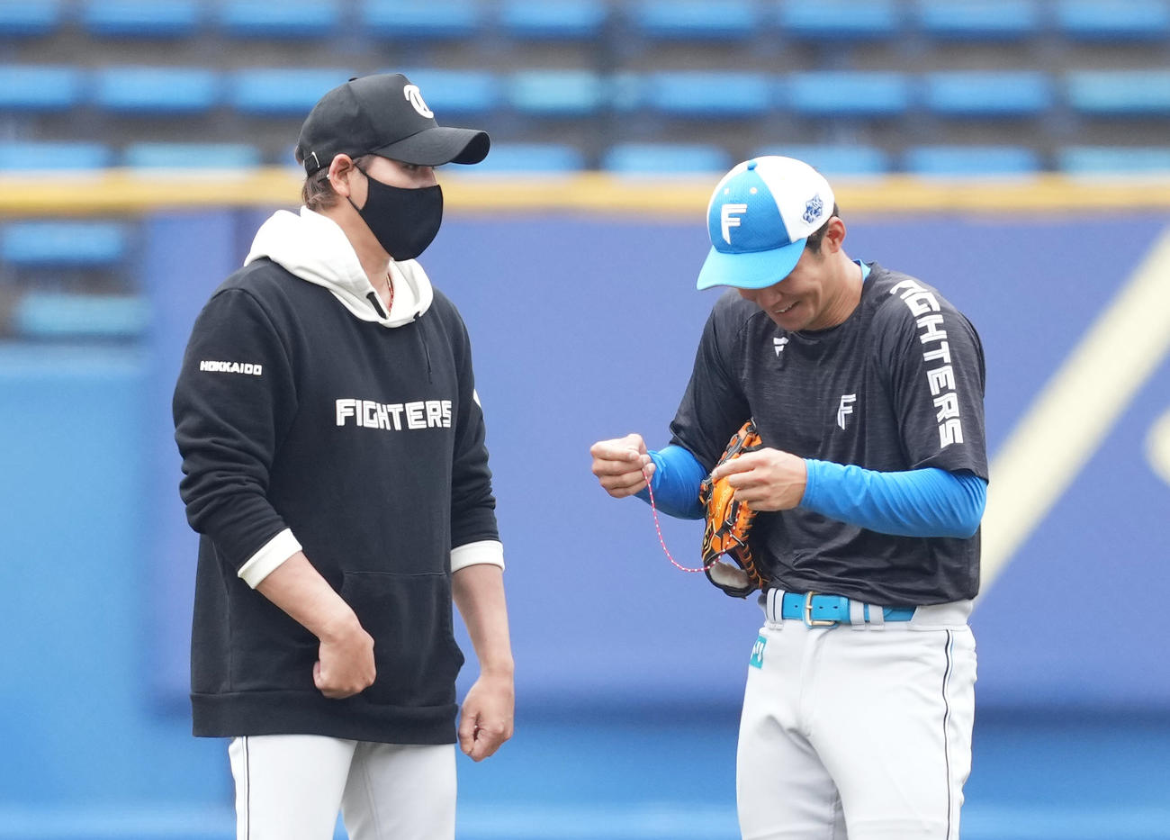 ロッテ対日本ハム　試合前、石井（右）につけていたネックレスをプレゼントする日本ハム新庄監督（撮影・菅敏）