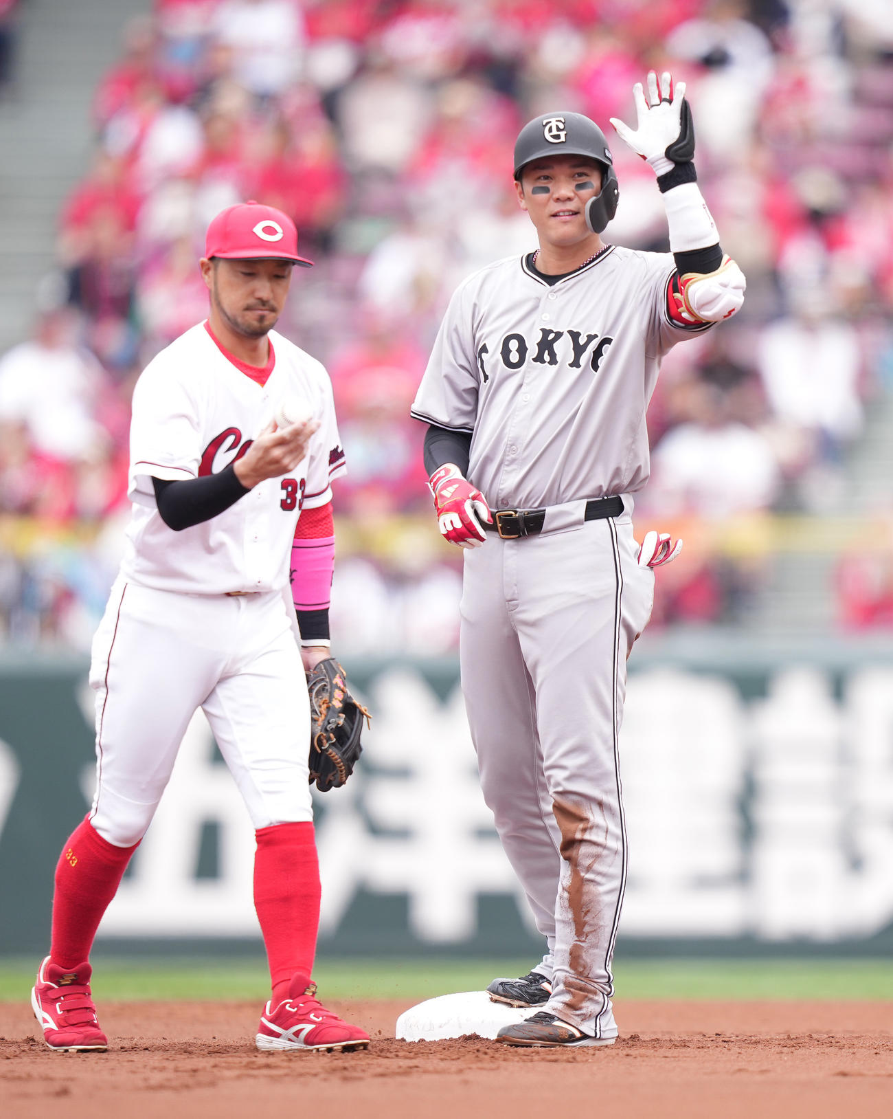 広島対巨人　1回表巨人2死一、二塁、先制の中適時二塁打を放った坂本は塁上で左手を挙げる。左は二塁手菊池（撮影・鈴木みどり）