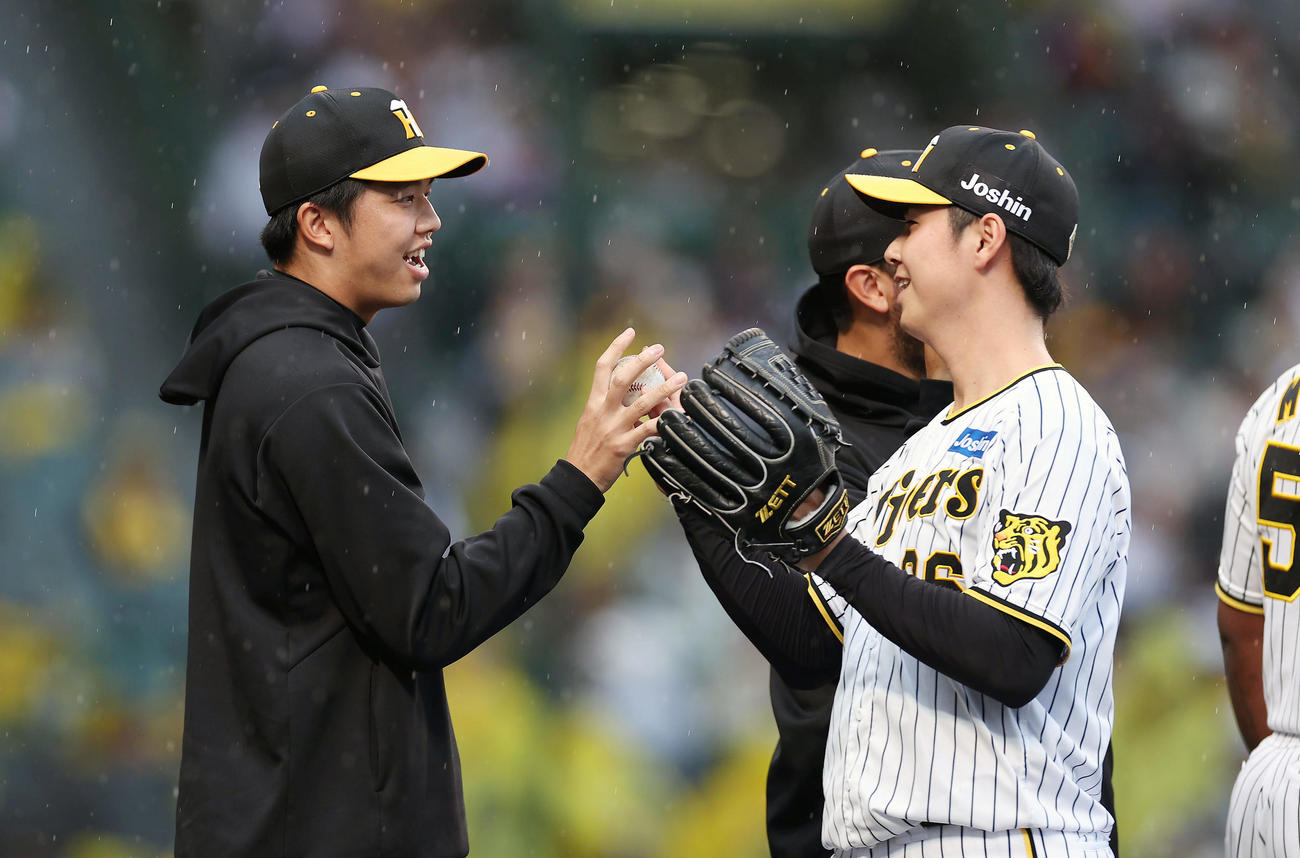 阪神対ヤクルト　ヤクルトに勝利し、阪神浜地（右）から勝利球を受け取る才木（撮影・前田充）