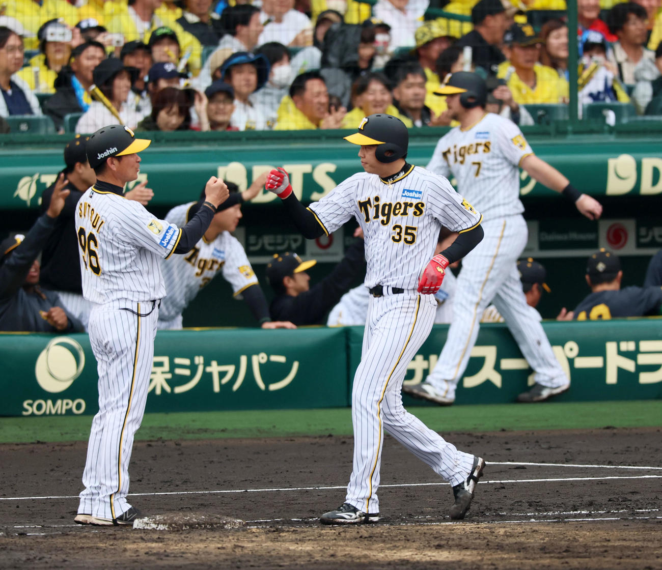 阪神対ヤクルト　4回裏阪神無死満塁、才木は押し出し四球を選んで勝ち越しに成功し筒井コーチ（左）とタッチ（撮影・加藤哉）