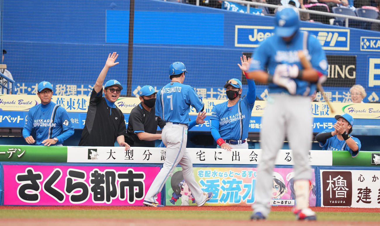 ロッテ対日本ハム　8回表日本ハム2死満塁、田宮の押し出しの四球で生還した松本剛（中央）をタッチで迎える新庄監督（右から2人目）（撮影・菅敏）