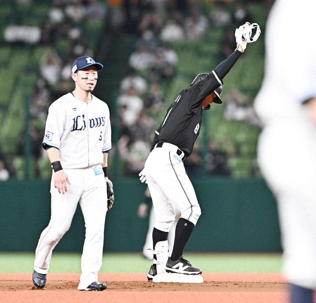 西武対ロッテ　1回表ロッテ1死満塁、中村奨（右）は左翼に2点適時二塁打を放ちベンチへ向かってポーズを決める。二塁手外崎（撮影・滝沢徹郎）