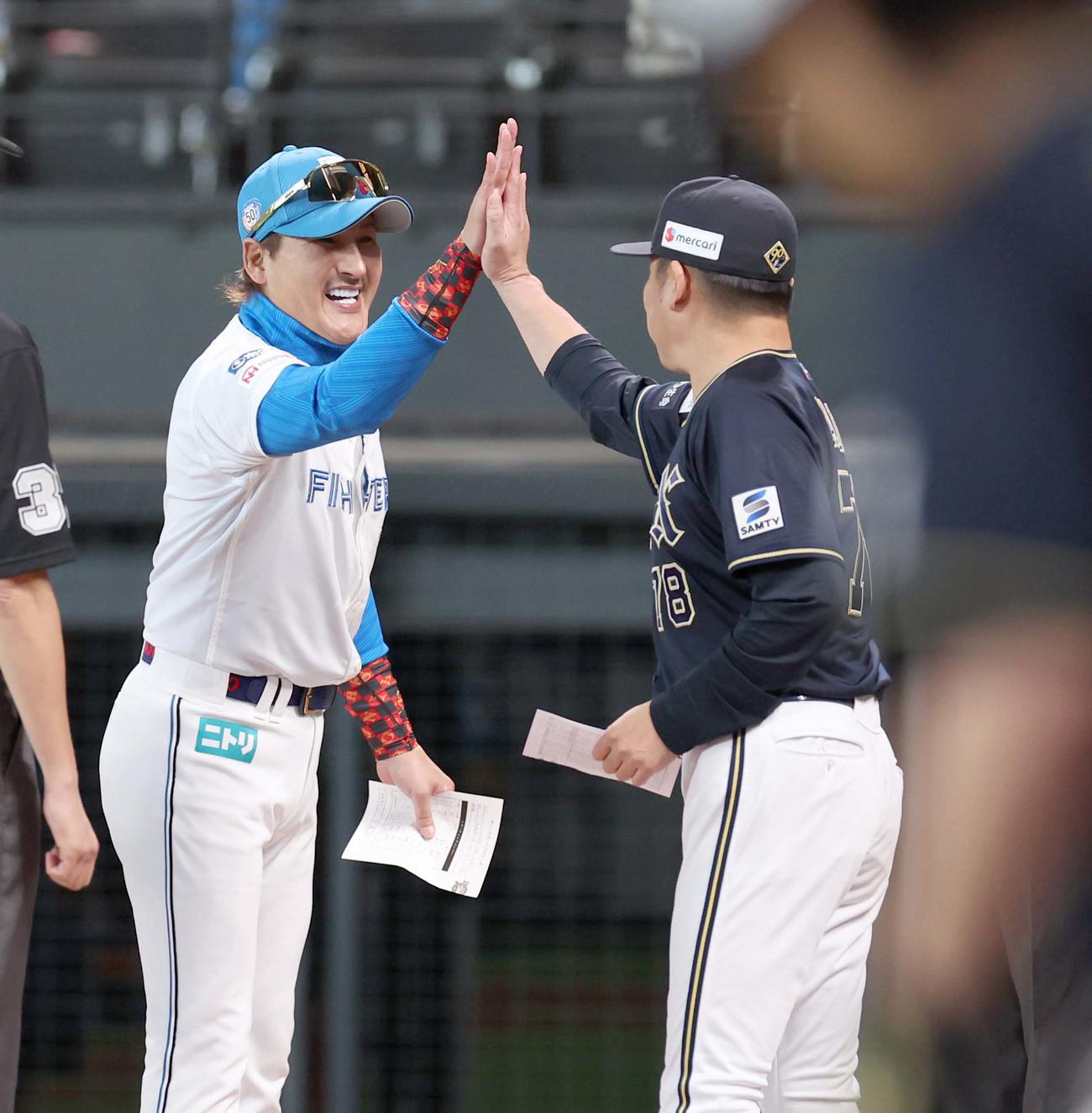 日本ハム対オリックス　メンバー表交換で中嶋監督とハイタッチする新庄監督（撮影・黒川智章）