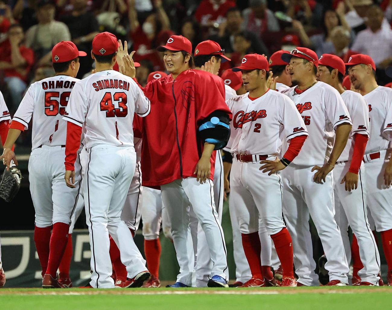 広島対阪神　5勝目を挙げた床田（中央）は笑顔でナインを出迎える（撮影・上田博志）