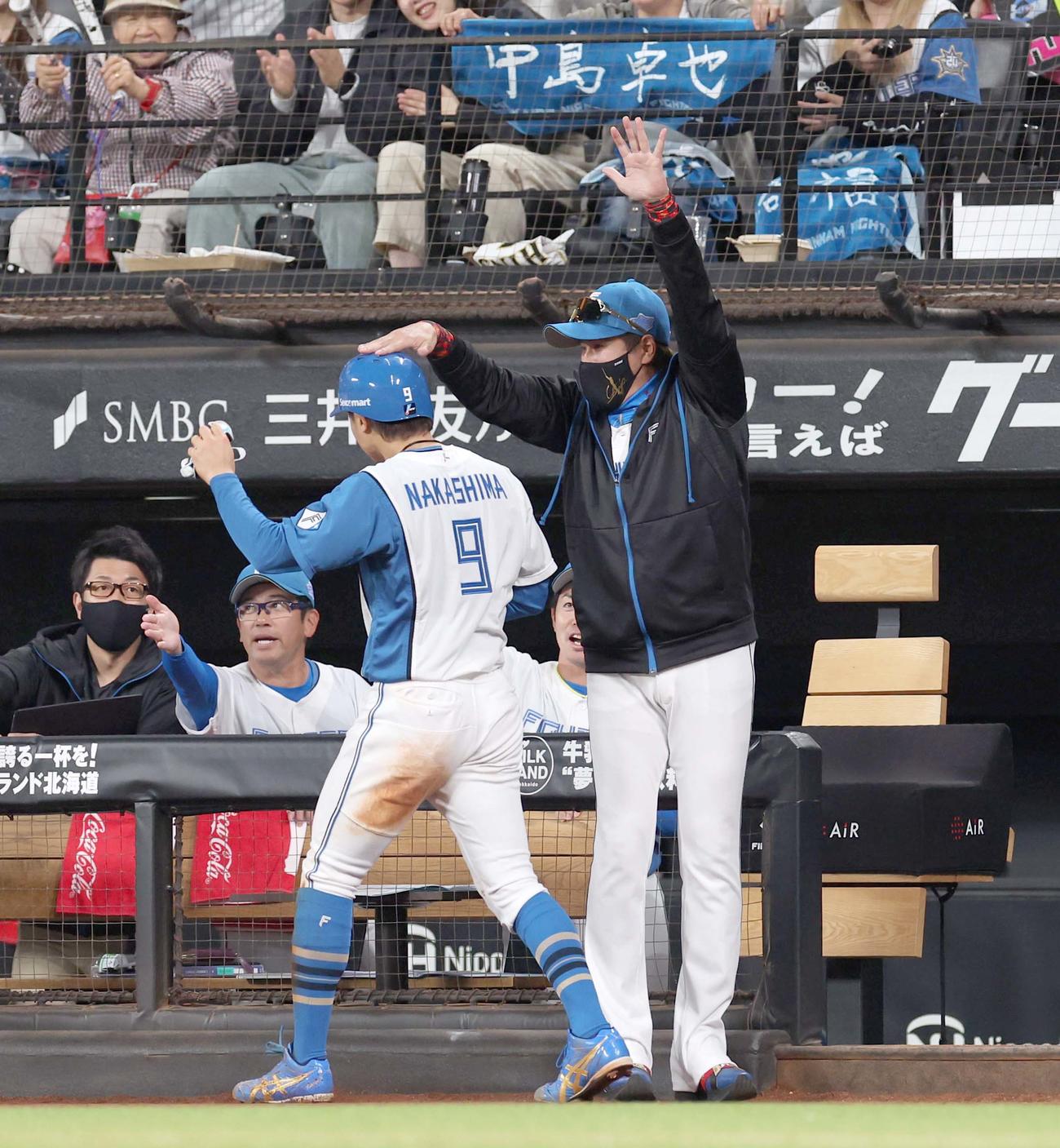 日本ハム対オリックス　3回裏、生還した中島を出迎える新庄監督（撮影・黒川智章）