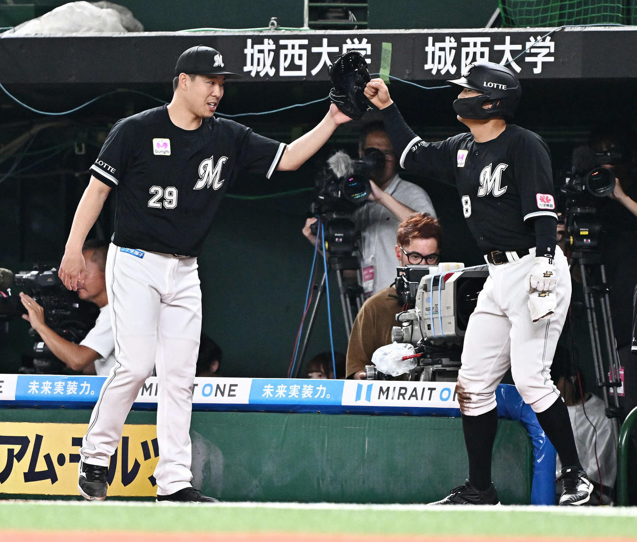 西武対ロッテ　1回表ロッテ1死一、三塁、安田の2点適時二塁打で生還した中村奨（左）は西野とタッチをかわす（撮影・滝沢徹郎）
