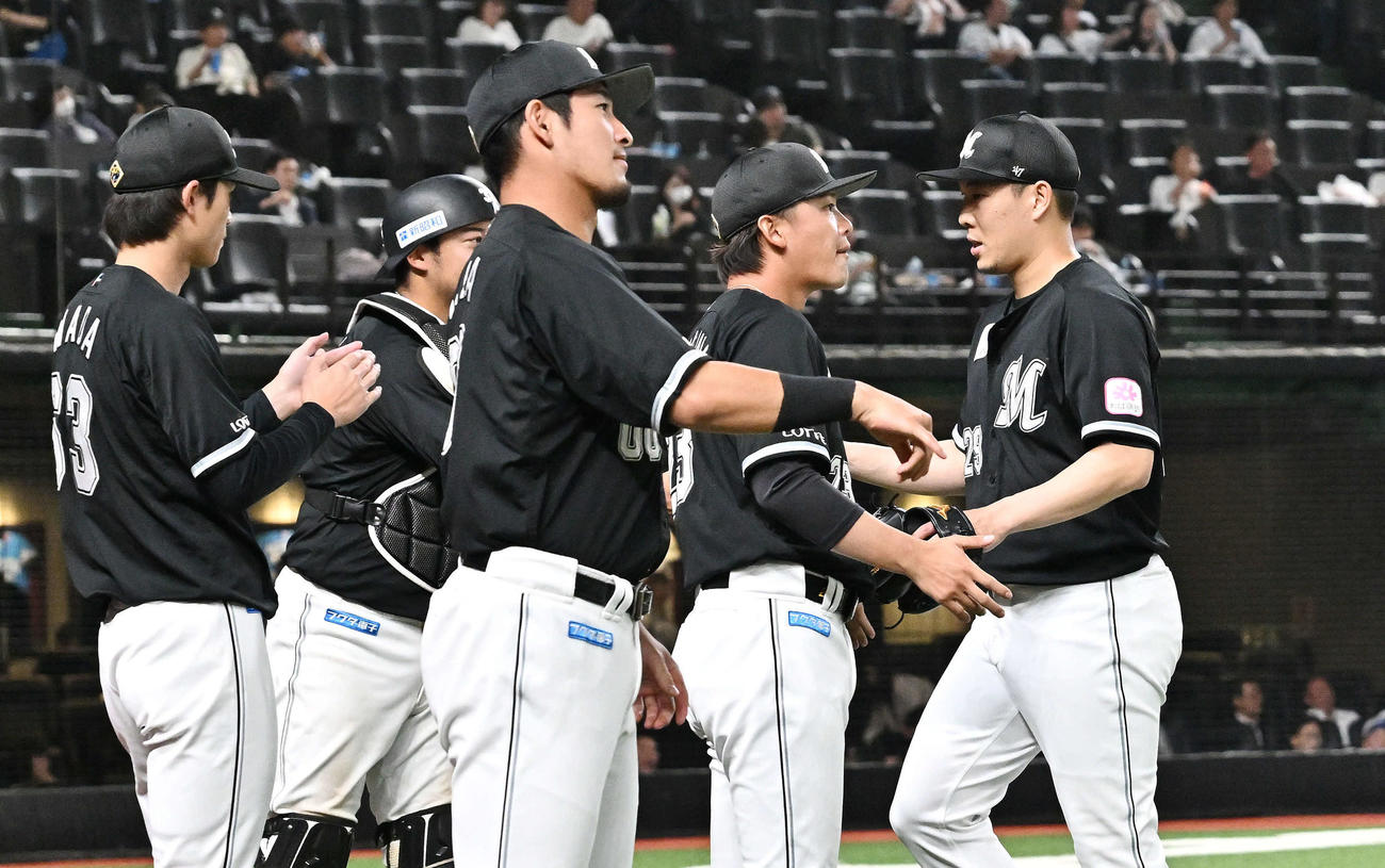 西武対ロッテ　6回裏を投げ終えたロッテ先発の西野（右）はチームメートとタッチをかわす（撮影・滝沢徹郎）