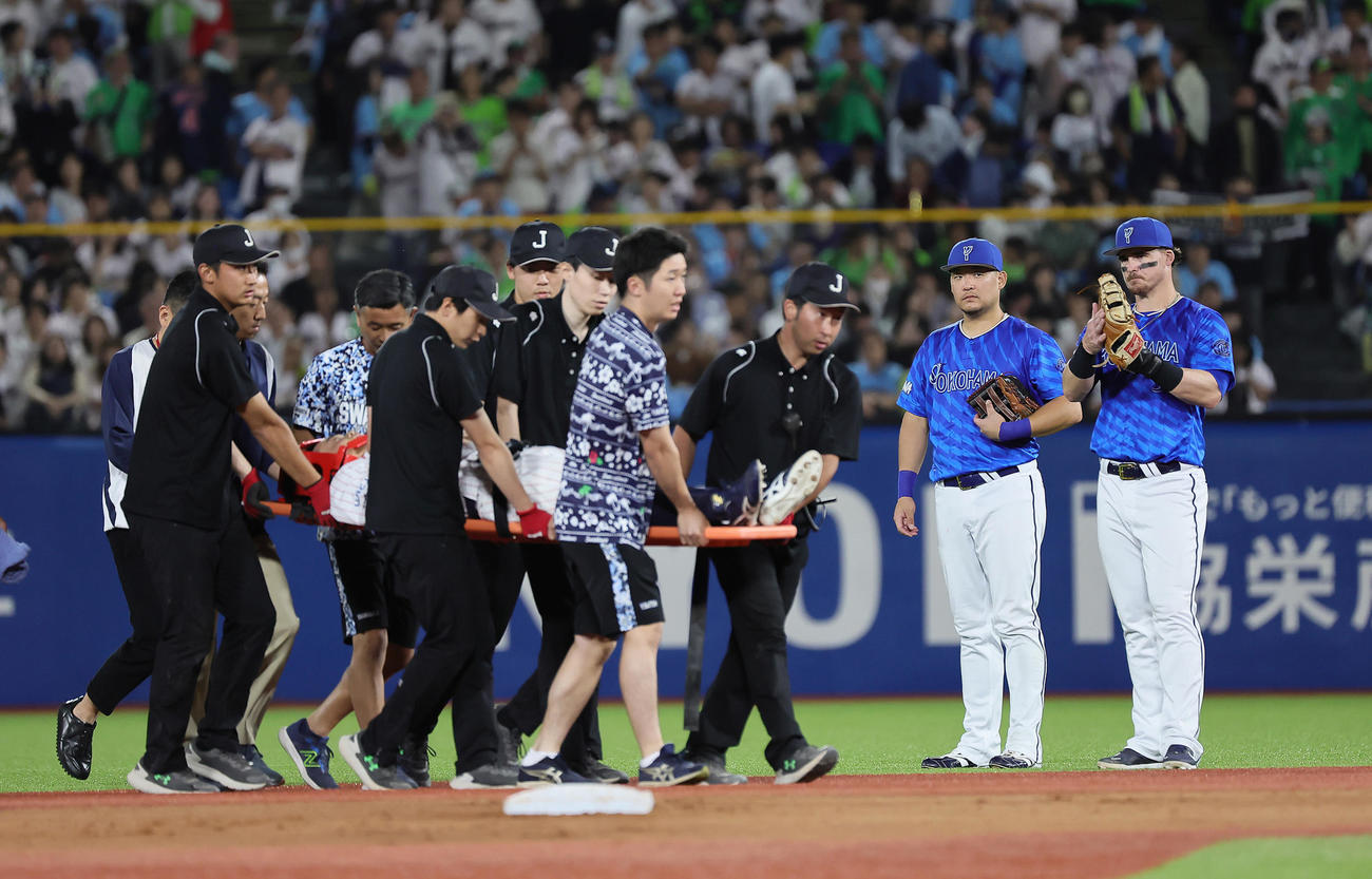 ヤクルト対DeNA 6回表ヤクルト2死一、二塁、宮崎の打球を好捕するも、負傷し担架で運ばれる丸山和を心配そうに見つめる筒香（右から2人目）とオースティン（撮影・足立雅史）