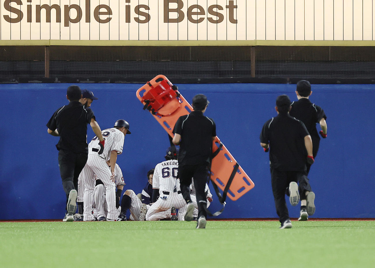 ヤクルト対DeNA 6回表ヤクルト2死一、二塁、宮崎の打球を好捕するもフェンスにぶつかり倒れ込む中堅手丸山和に担架が運び込まれる（撮影・足立雅史）