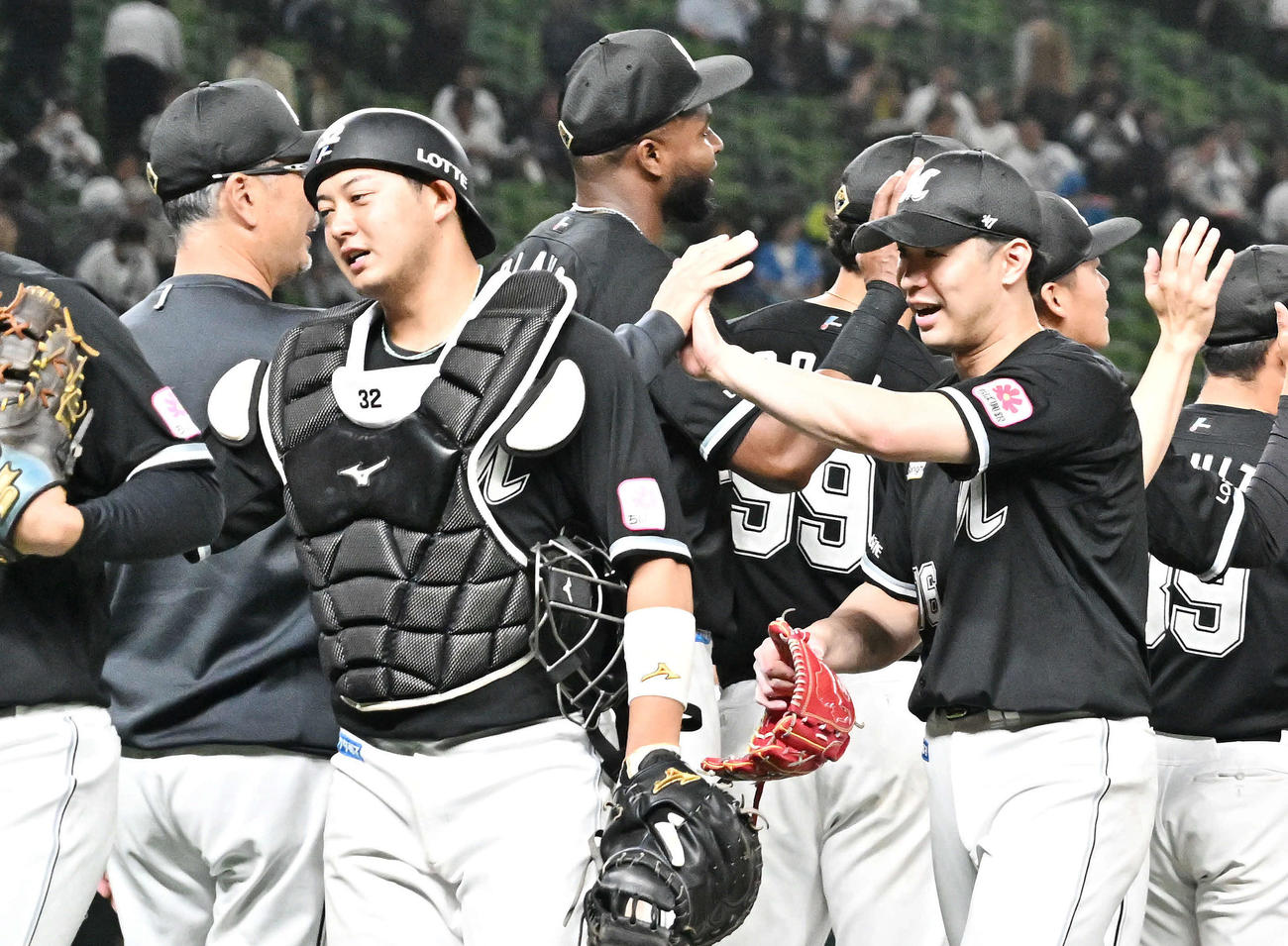西武対ロッテ　試合後、完投勝利したロッテ種市（右手前）は吉井監督とタッチをかわす（撮影・滝沢徹郎）