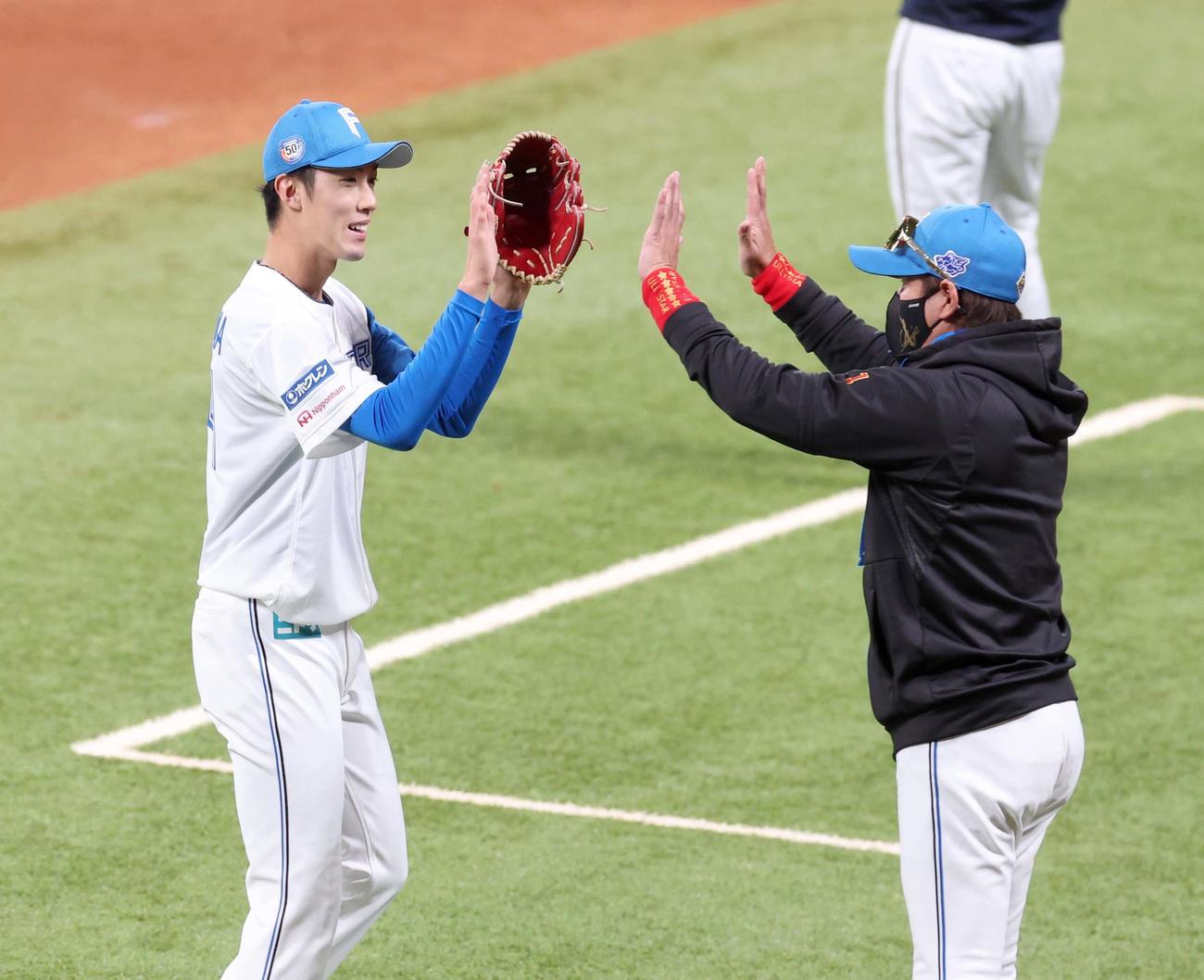 日本ハム対オリックス　6回途中まで無失点と好投した福島をハイタッチで出迎える新庄監督（撮影・黒川智章）