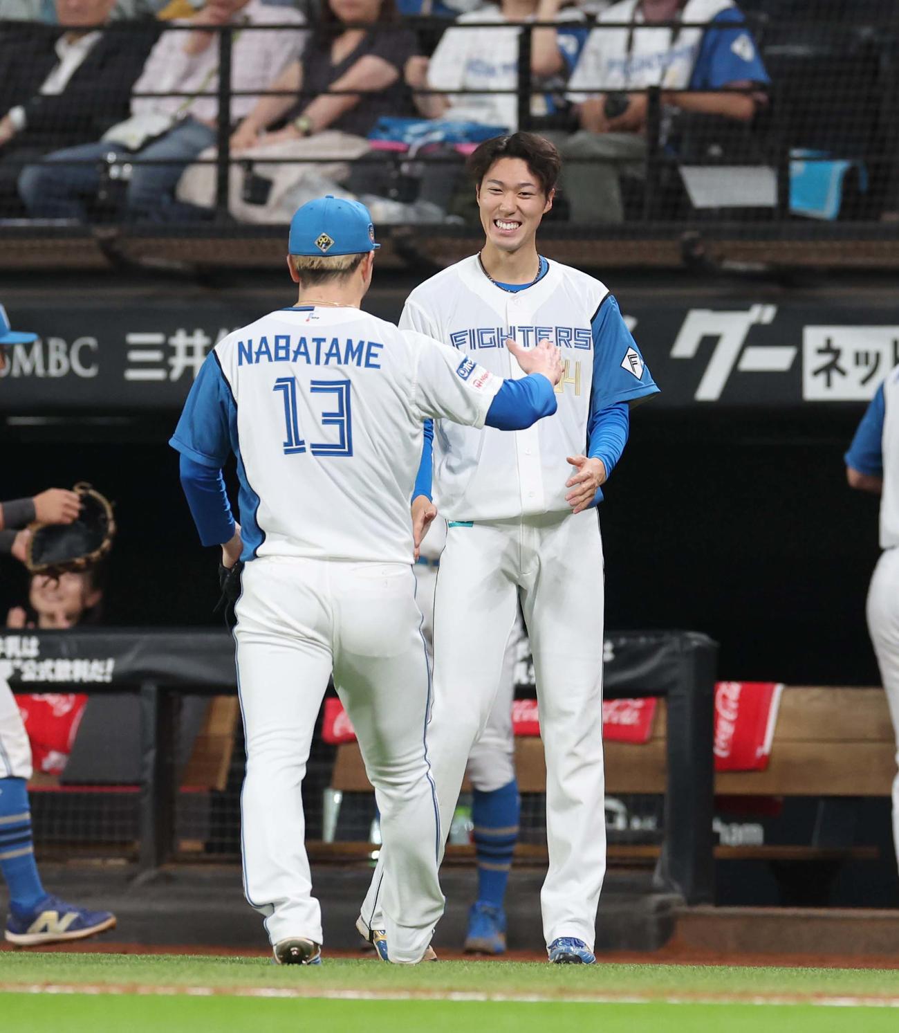 日本ハム対オリックス　6回表、2番手登板の生田目を笑顔で出迎える福島（撮影・黒川智章）
