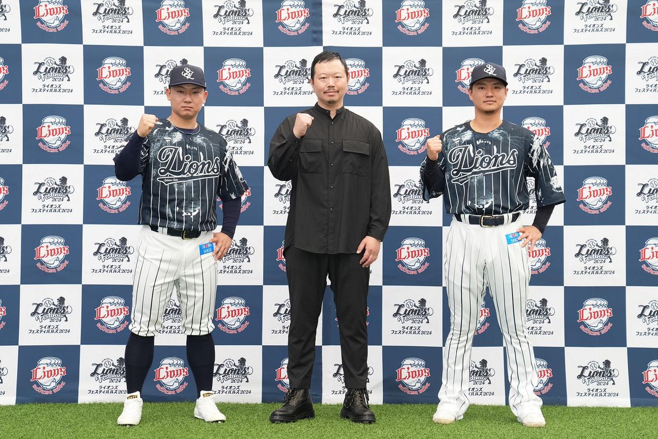 西武の限定ユニホーム「ハントブルーユニホーム」を着用する古賀（左）と佐藤龍（右）。中央はデザイナーの相沢洋介氏（写真は球団提供）