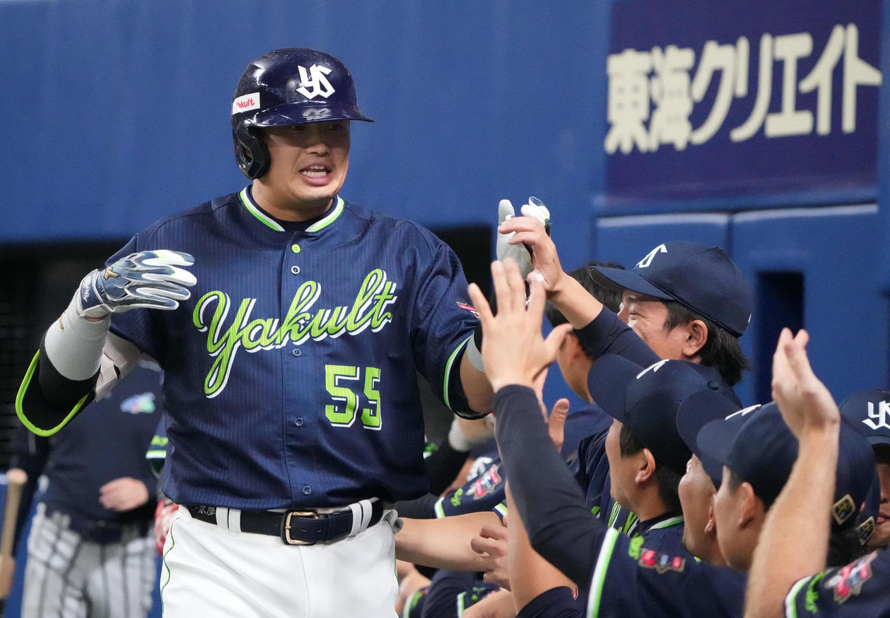 中日対ヤクルト　1回表ヤクルト2死一塁、中越え2点本塁打を放ちナインとタッチを交わす村上（左）（撮影・森本幸一）