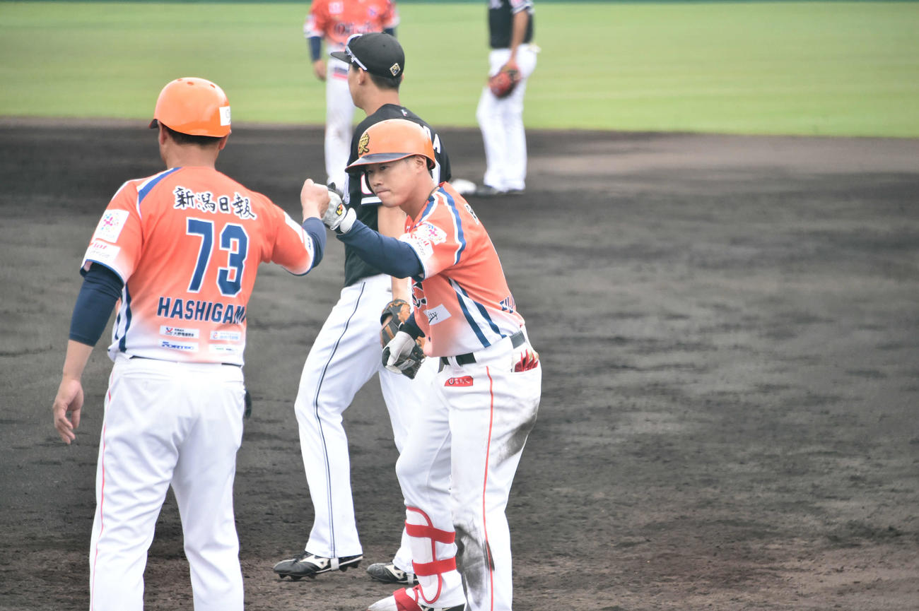 2回裏、勝ち越し適時打を放ったオイシックス藤原（右）は橋上監督とグータッチ