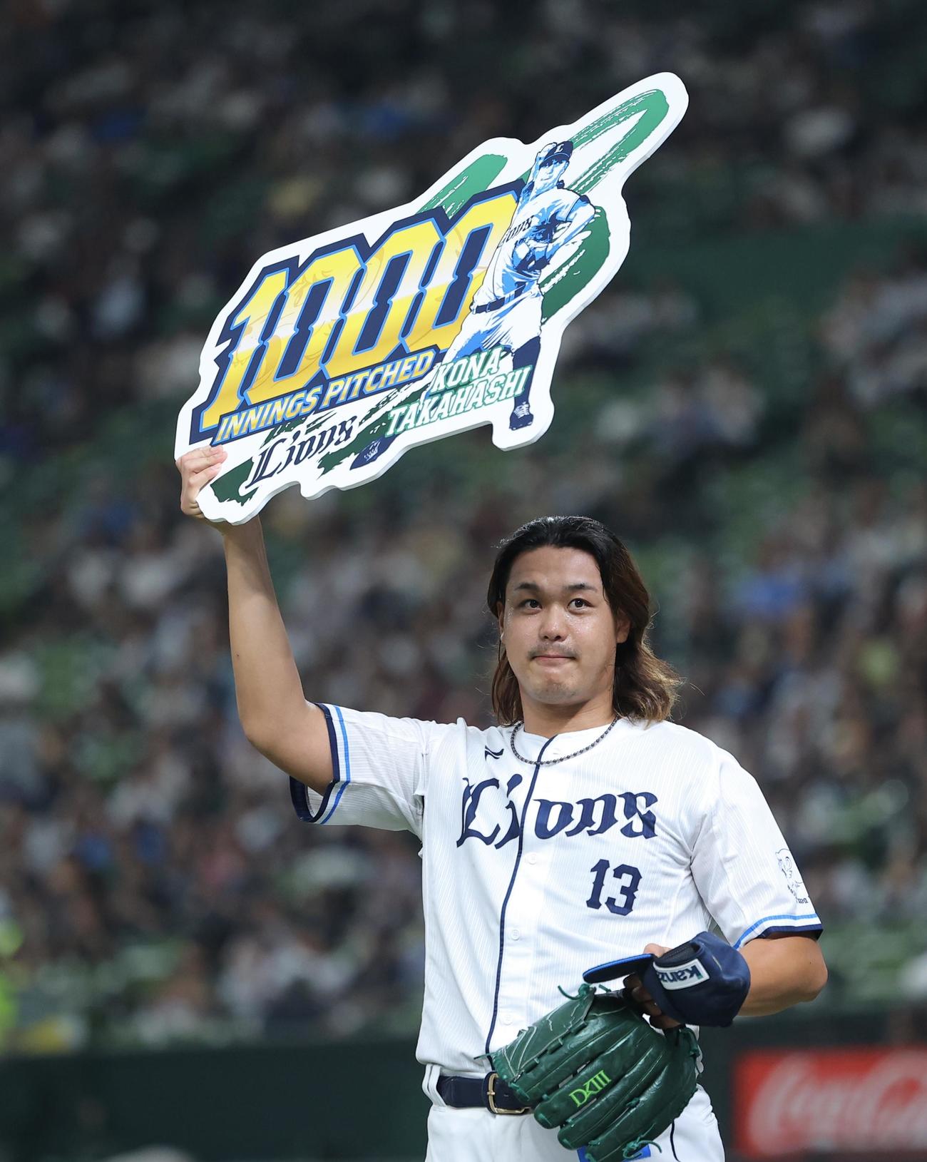 西武対オリックス　1回表を抑えた高橋は1000投球回を達成し、記念ボードを掲げる（撮影・河田真司）