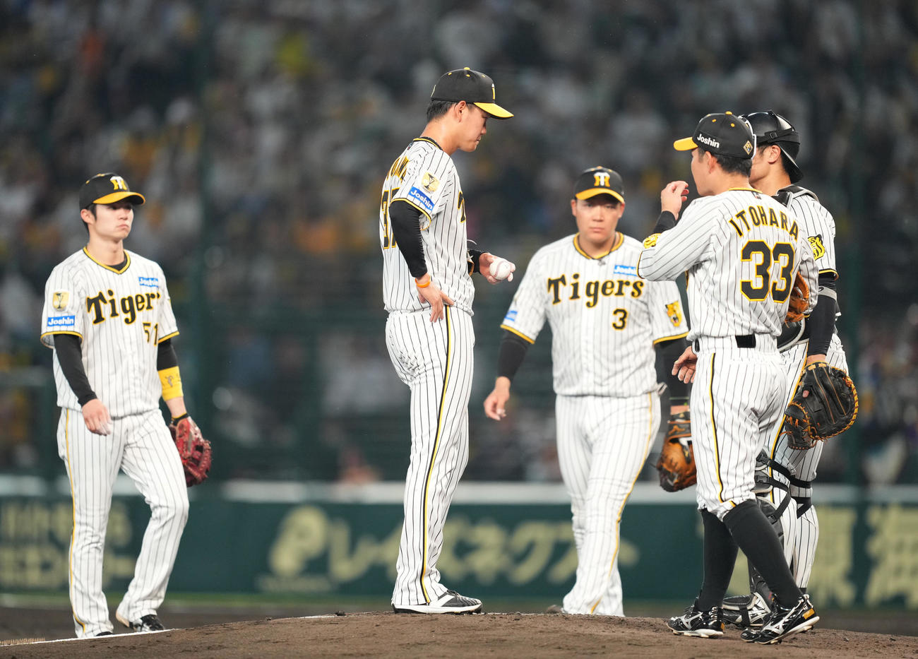 阪神対巨人　5回表巨人1死一塁、マウンドに集まるナインを前に肩を落とす及川（中央）（撮影・菅敏）